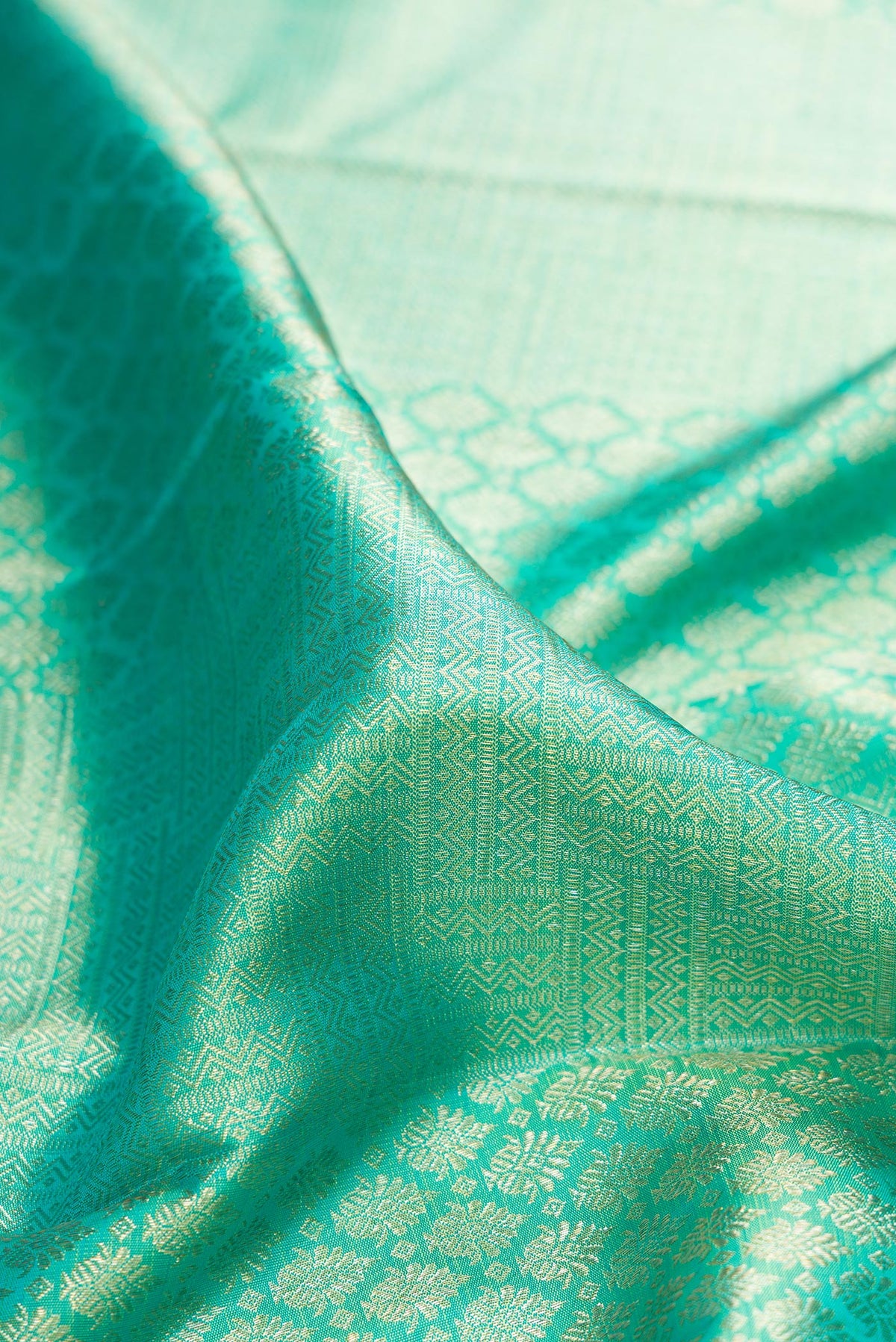 Close up of Pure Silk Sea Green Kanchipuram Saree with Zari Brocade on the body and Zari Border.  displaying folds