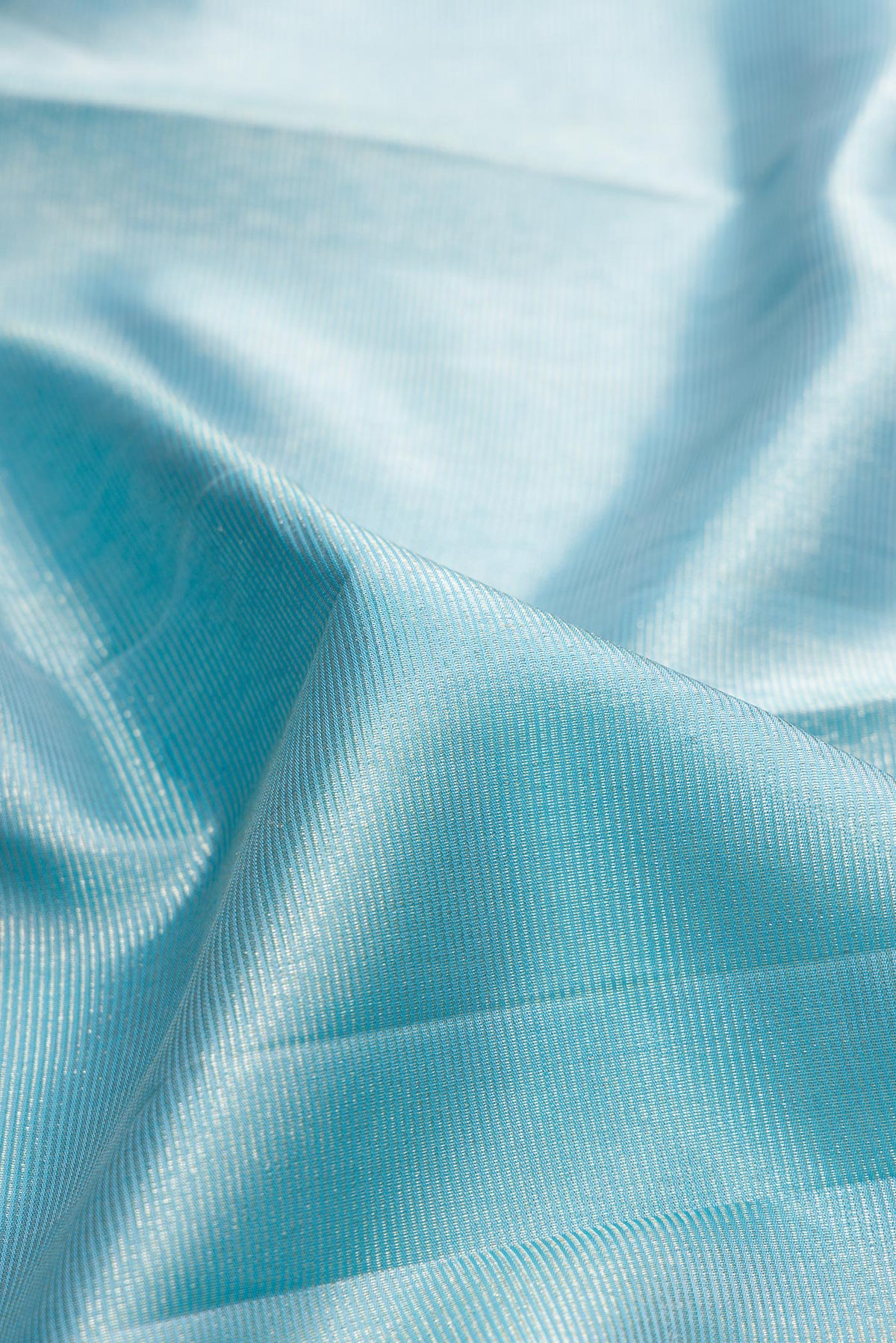 Close up of Pure Silk Sky Blue Kanchipuram Saree with Zari Brocade on the body and Zari Border.  displaying folds