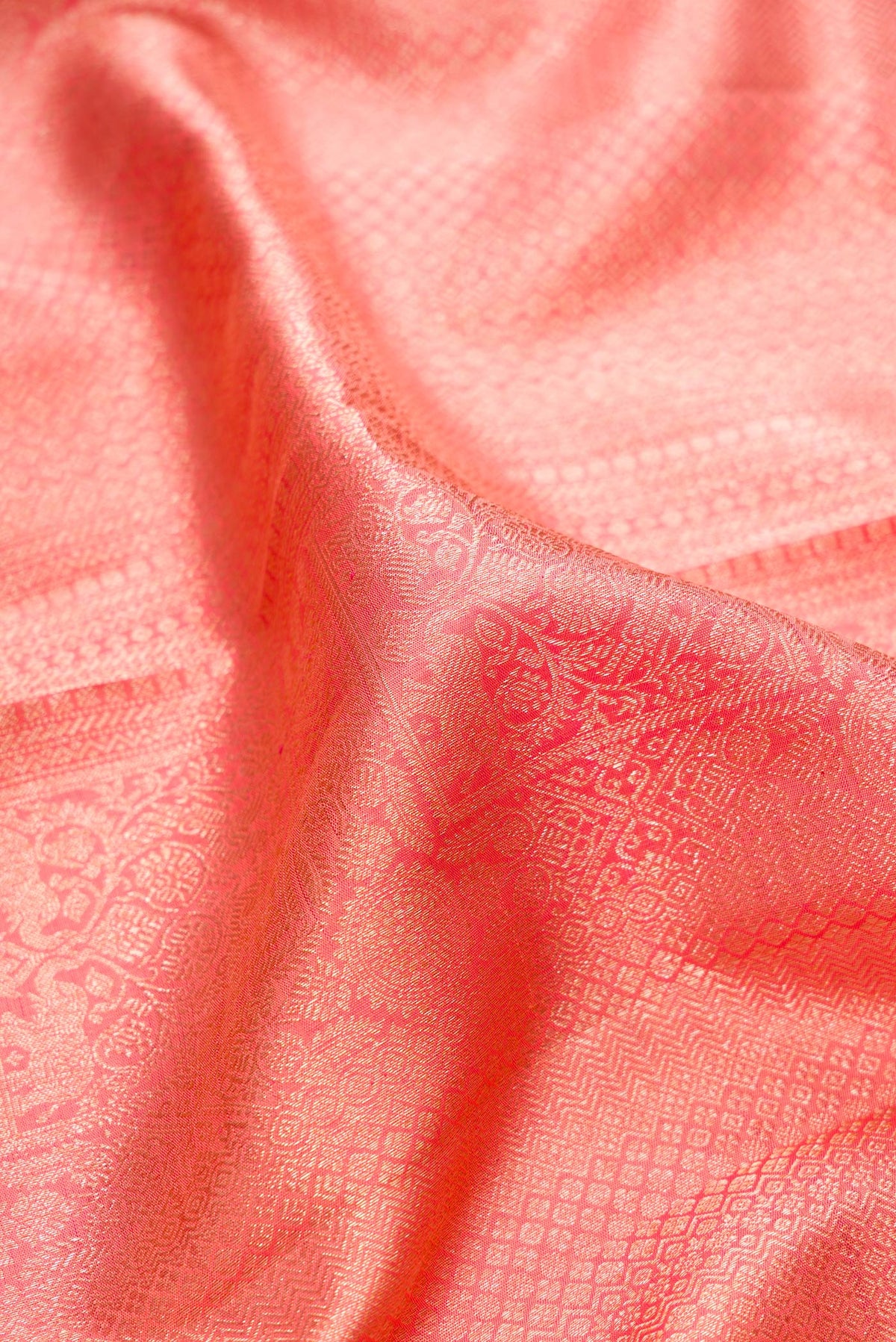 Close up of Pure Silk Golden Peach Dual Tone Kanchipuram Saree with Zari Brocade on the body and Zari Border.  displaying folds