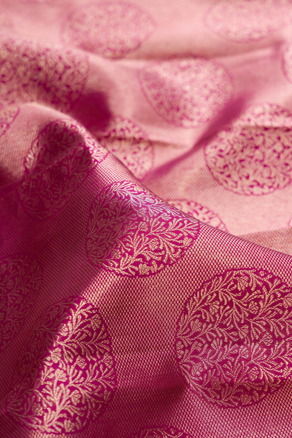 Close up of Pure Silk Dark Pink Kanchipuram Saree with Zari Brocade on the body and Zari Border.  displaying folds