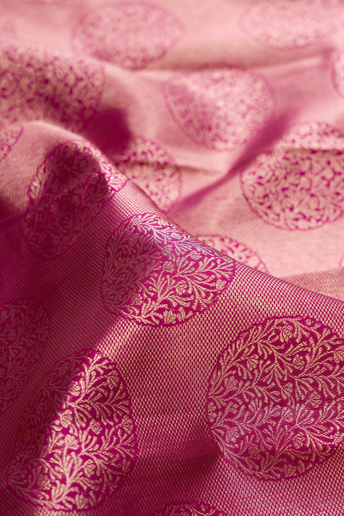 Close up of Pure Silk Dark Pink Kanchipuram Saree with Zari Brocade on the body and Zari Border.  displaying folds