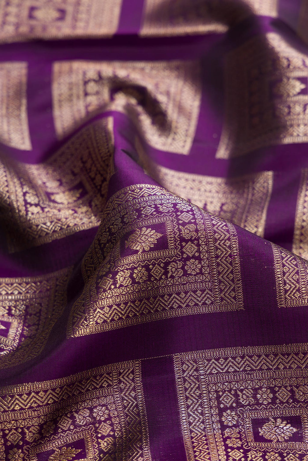 Close up of Pure Silk Violet Kanchipuram Saree with Zari Brocade on the body and Zari Border.  displaying folds