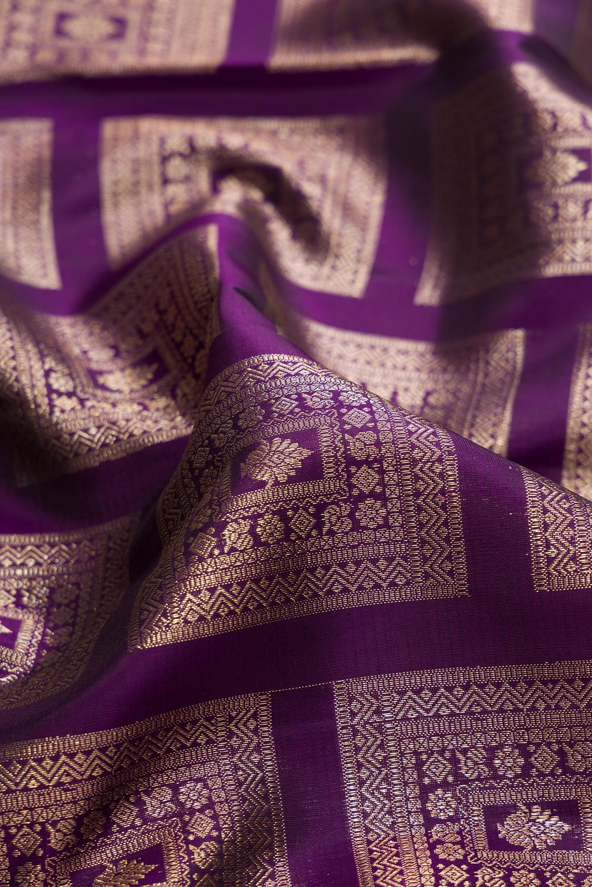 Close up of Pure Silk Violet Kanchipuram Saree with Zari Brocade on the body and Zari Border.  displaying folds