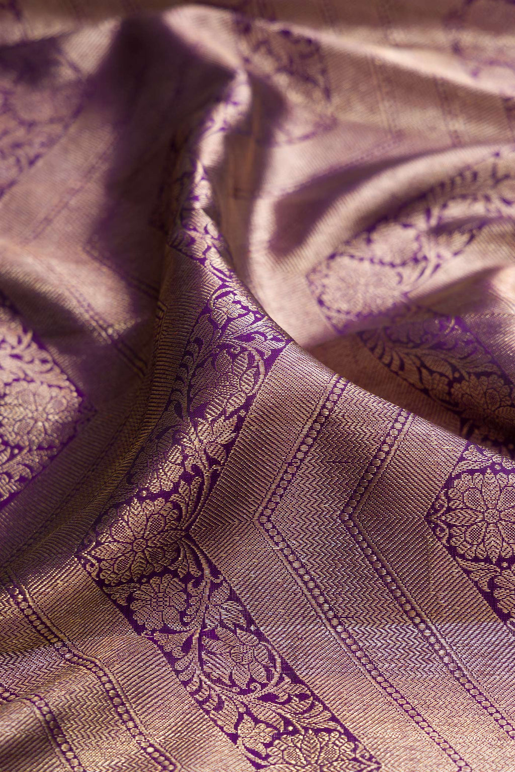 Close up of Pure Silk Purple Kanchipuram Saree with Zari Brocade on the body and Zari Border.  displaying folds