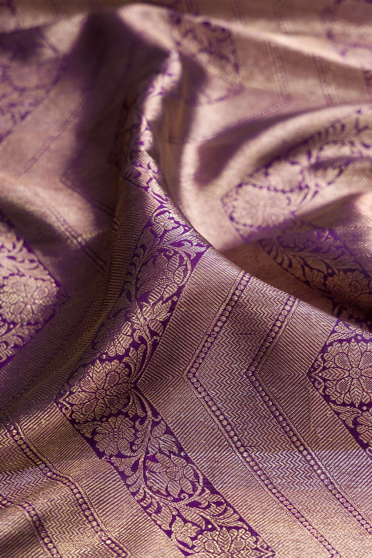 Close up of Pure Silk Purple Kanchipuram Saree with Zari Brocade on the body and Zari Border.  displaying folds