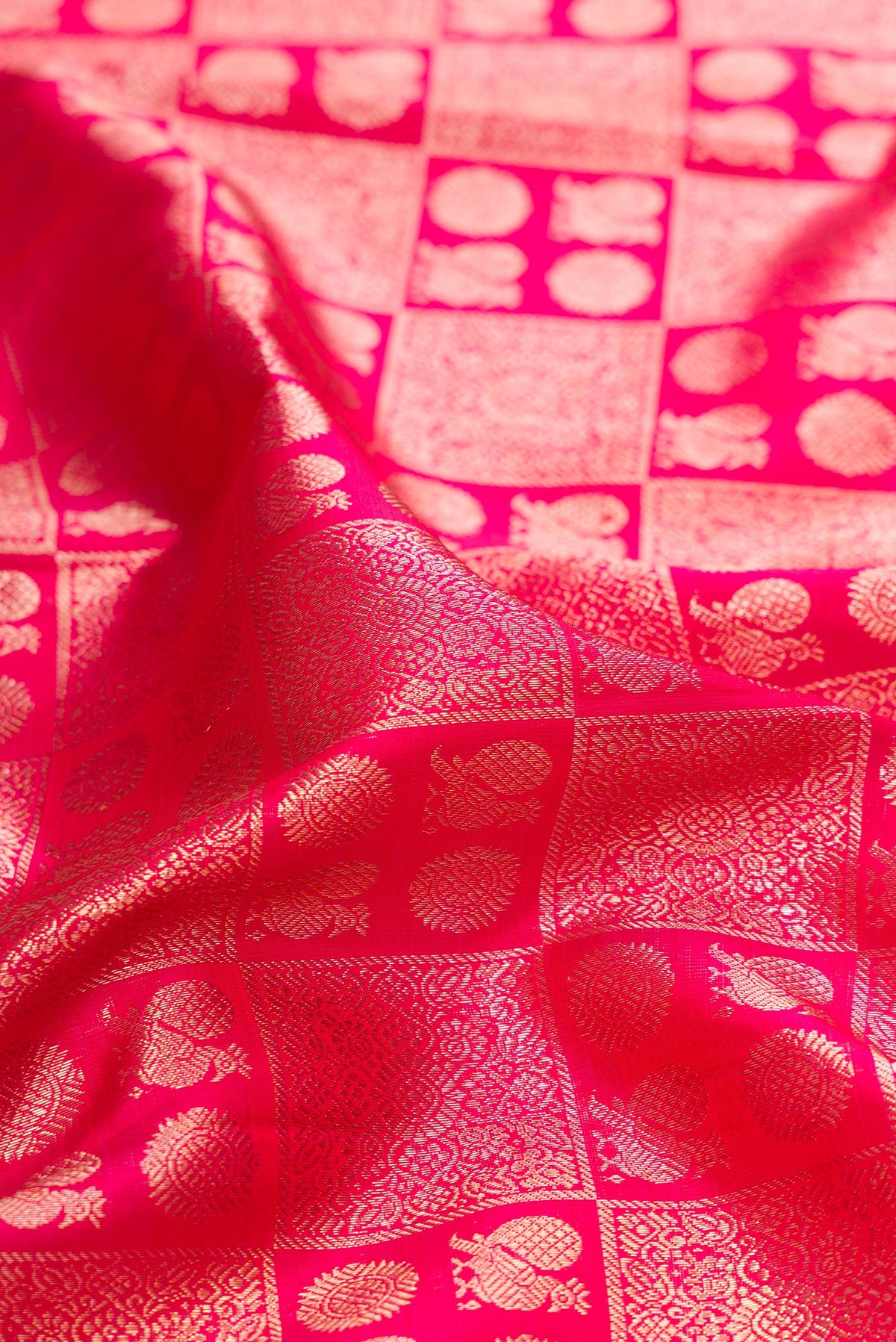 Close up of Pure Silk Dark Pink Kanchipuram Saree with Zari Brocade on the body and Zari Border.  displaying folds