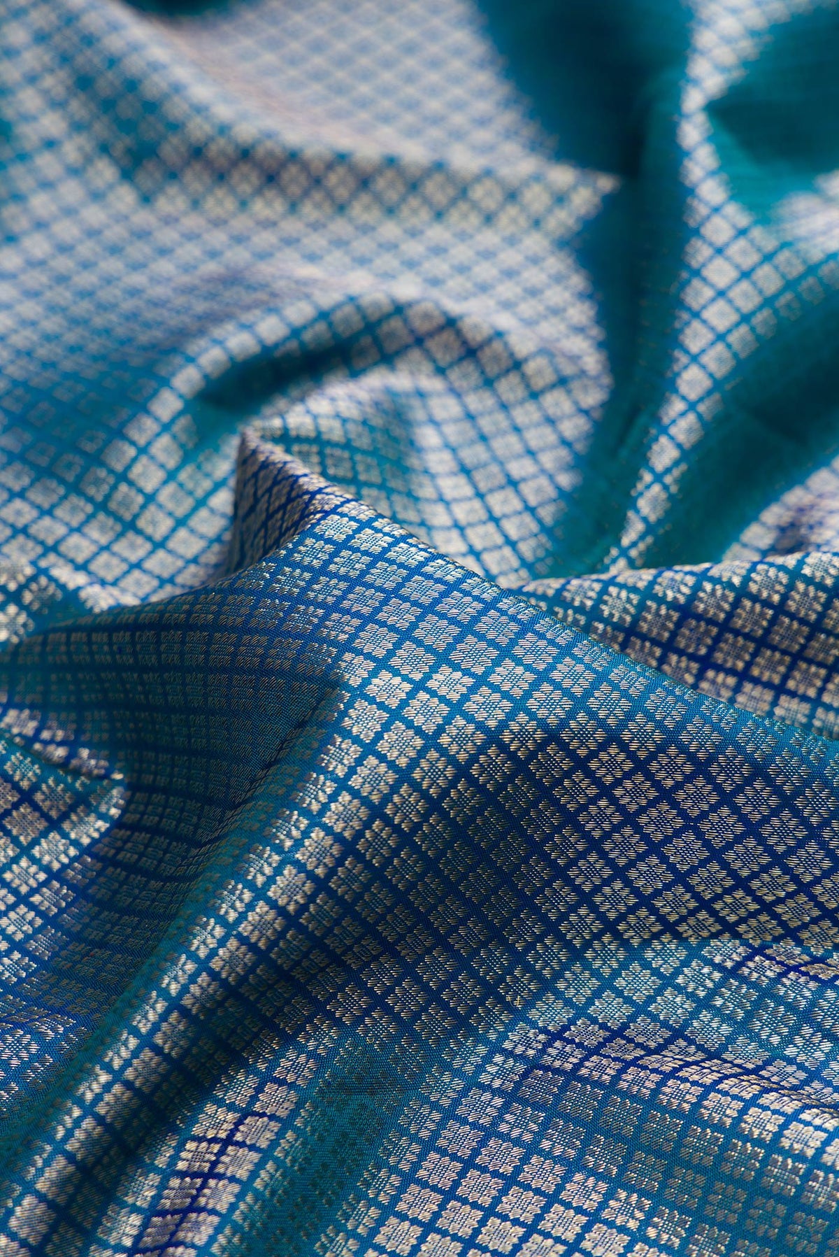 Close up of Pure Silk Peacock Blue Kanchipuram Saree with Zari Brocade on the body and Fancy Border.  displaying folds