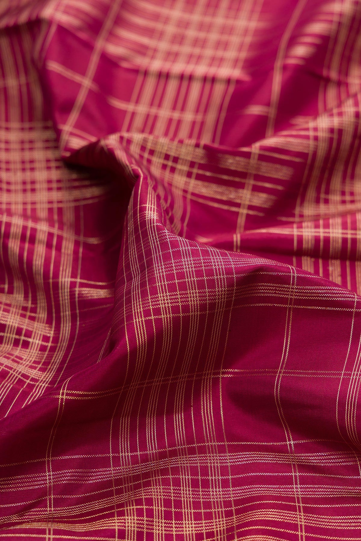 Close up of Pure Silk Maroon Dual Tone Kanchipuram Saree with Checked design on the body and Zari Border.  displaying folds