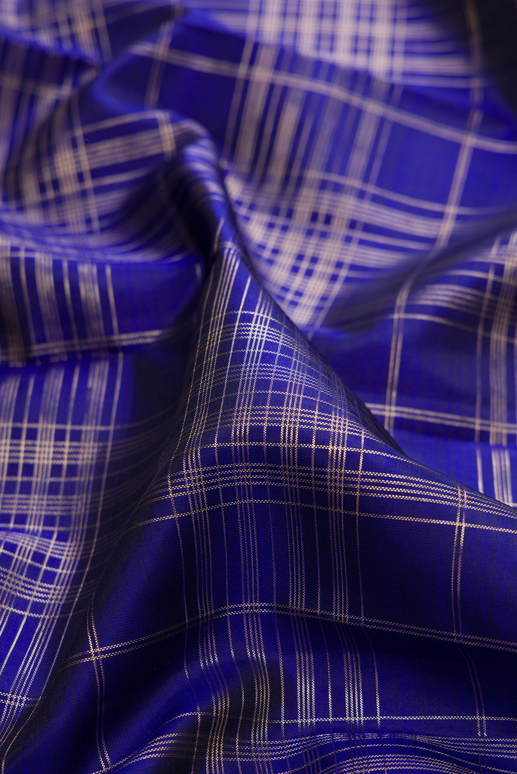 Close up of Pure Silk Royal Blue Kanchipuram Saree with Checked design on the body and Zari Border.  displaying folds