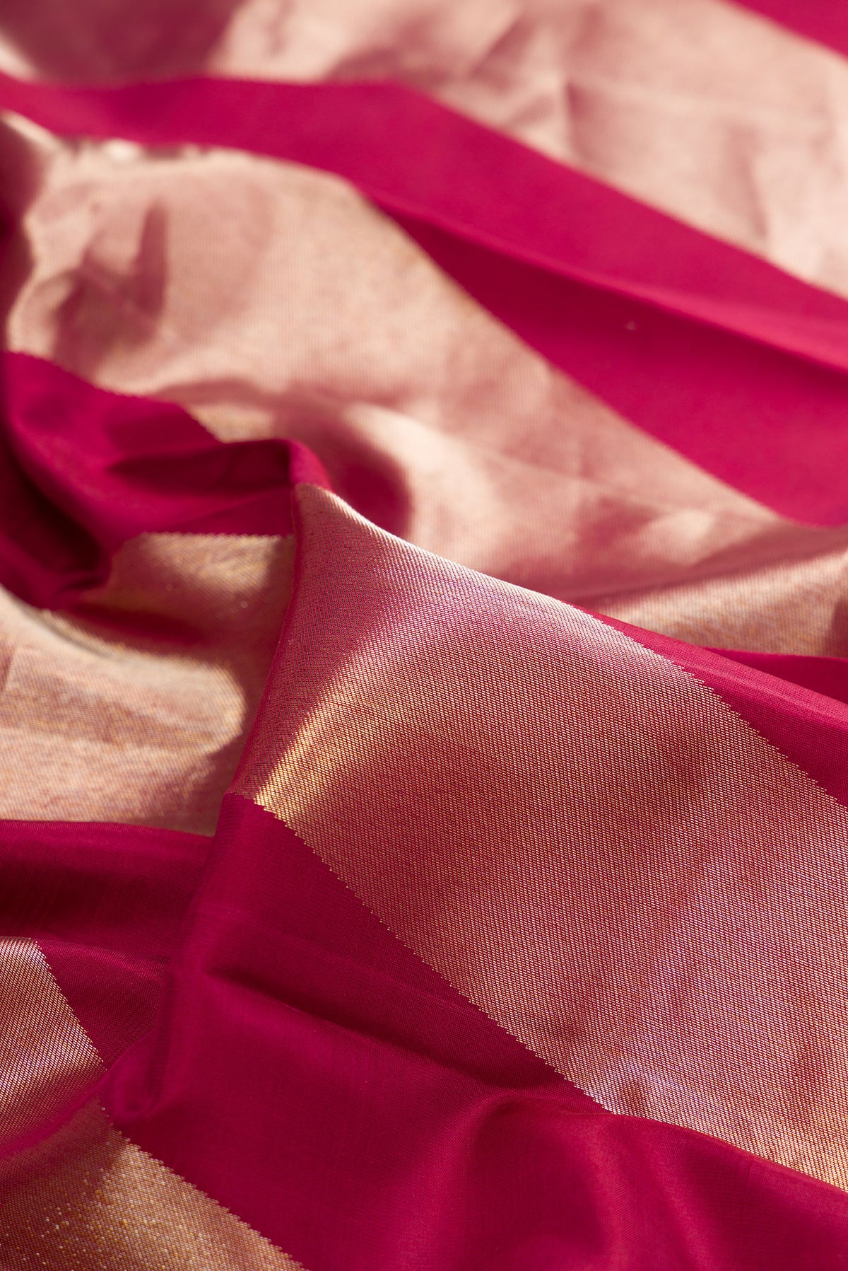 Close up of Pure Silk Maroon Kanchipuram Saree with Zari Butta on the body and Zari Border.  displaying folds
