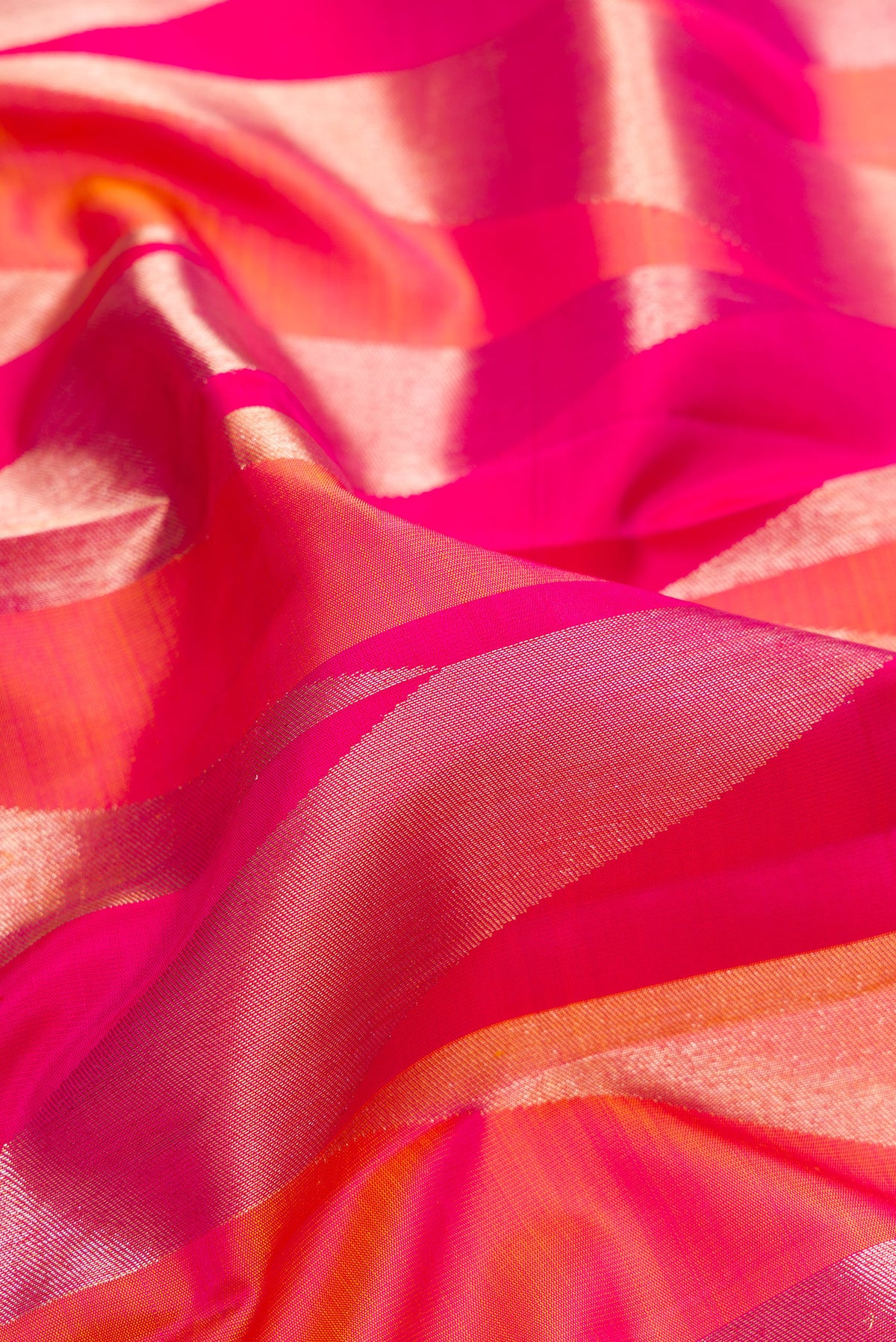 Close up of Pure Silk Dark Pink Dual Tone Kanchipuram Saree with Zari Brocade on the body and Zari Border.  displaying folds