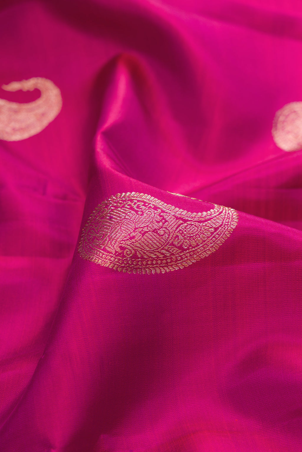 Close up of Pure Silk Pink Kanjivaram Saree with Zari Butta on the body and Fancy Border.  displaying folds