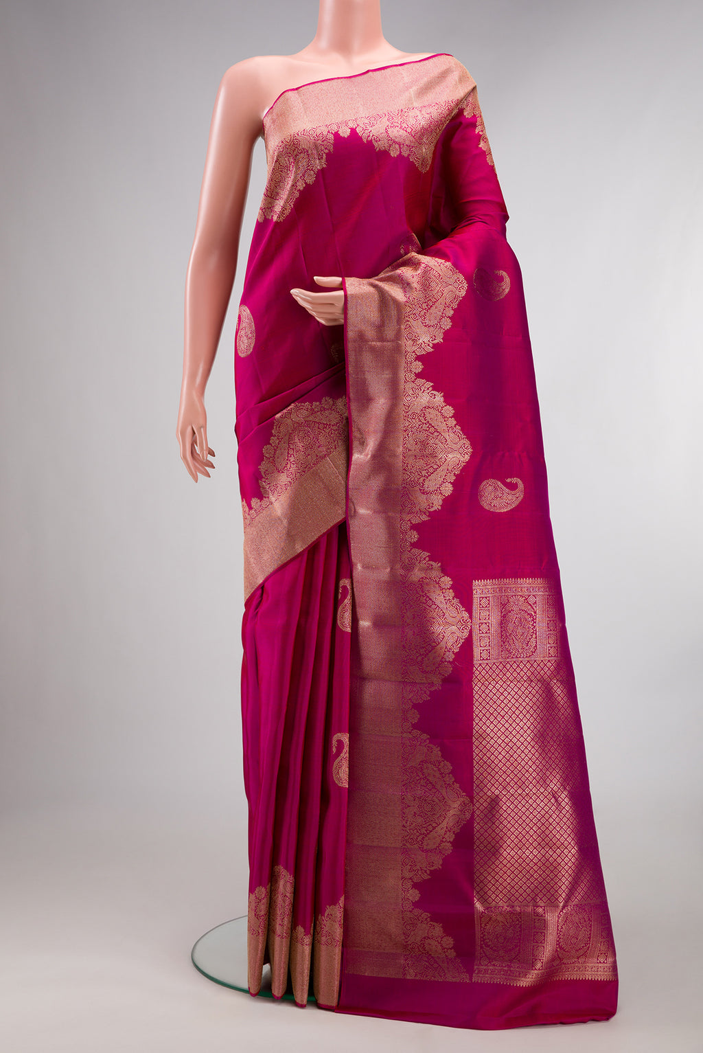 Pure Silk Pink Kanjivaram Saree with Zari Butta on the body and Fancy Border.  displayed on a mannequin
