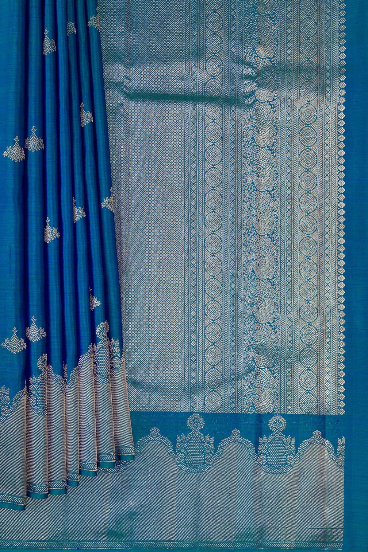 Pleats and pallu of Pure Silk Peacock Blue Dual Tone Kanjivaram Saree with Zari Butta on the body and Fancy Border. 