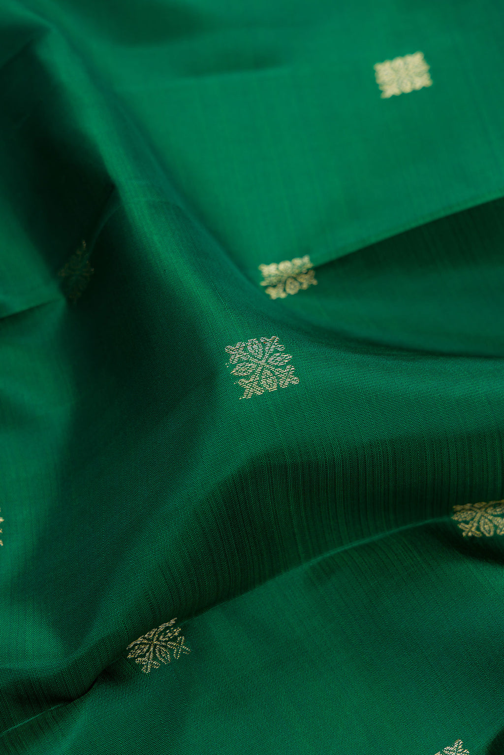 Close up of Pure Silk Green Kanjivaram Saree with Zari Butta on the body and Temple Border.  displaying folds