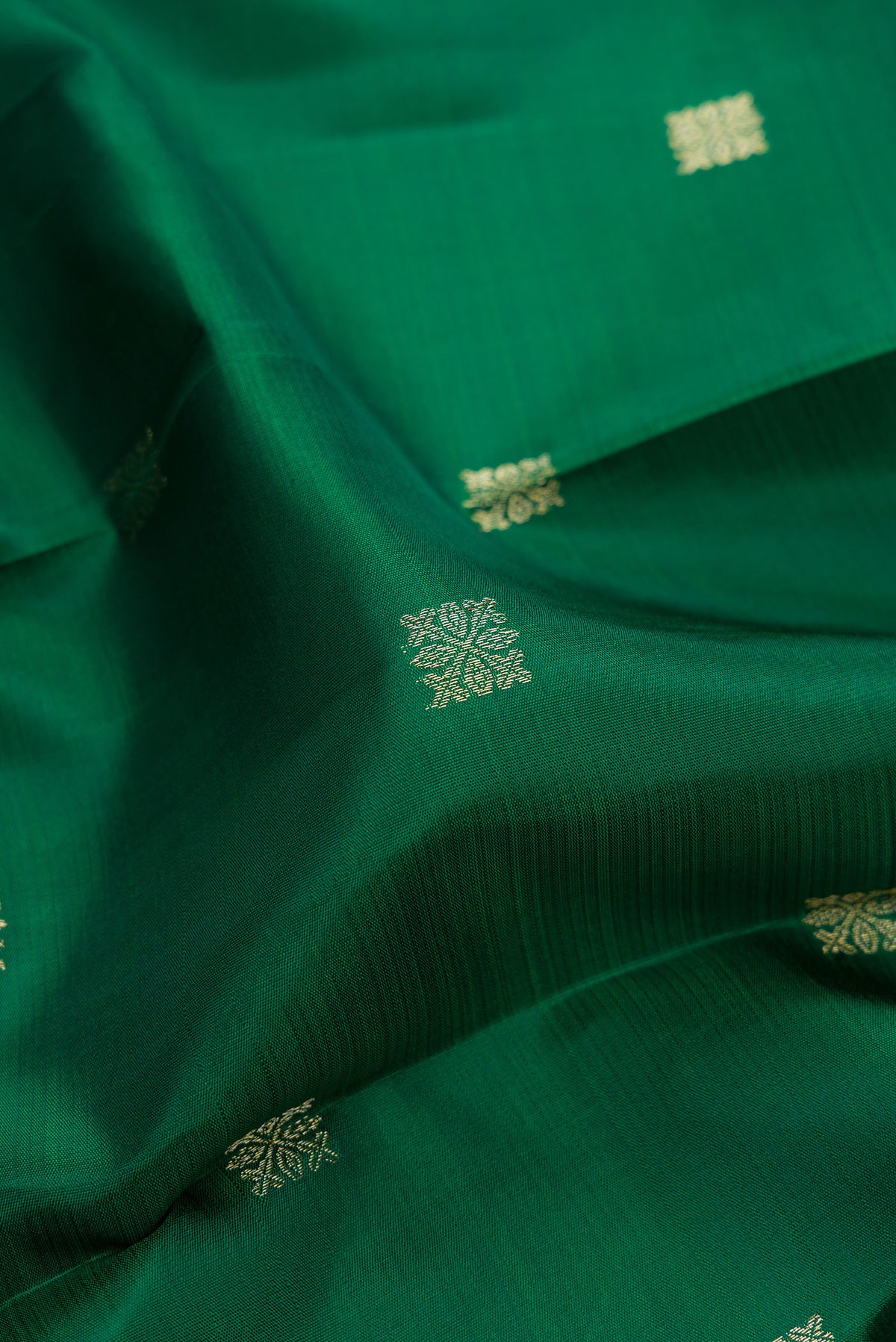 Close up of Pure Silk Green Kanjivaram Saree with Zari Butta on the body and Temple Border.  displaying folds