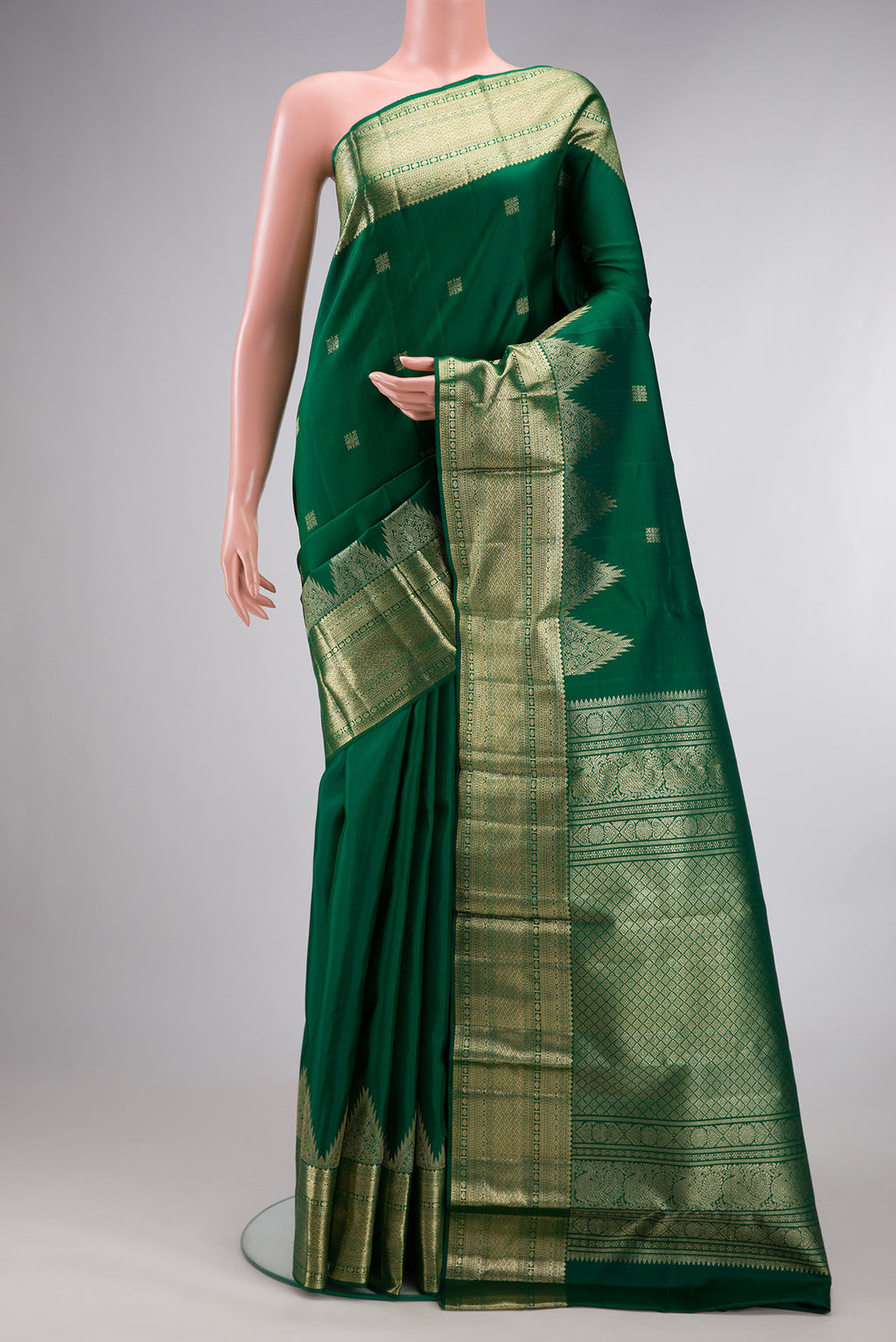 Pure Silk Green Kanjivaram Saree with Zari Butta on the body and Temple Border.  displayed on a mannequin