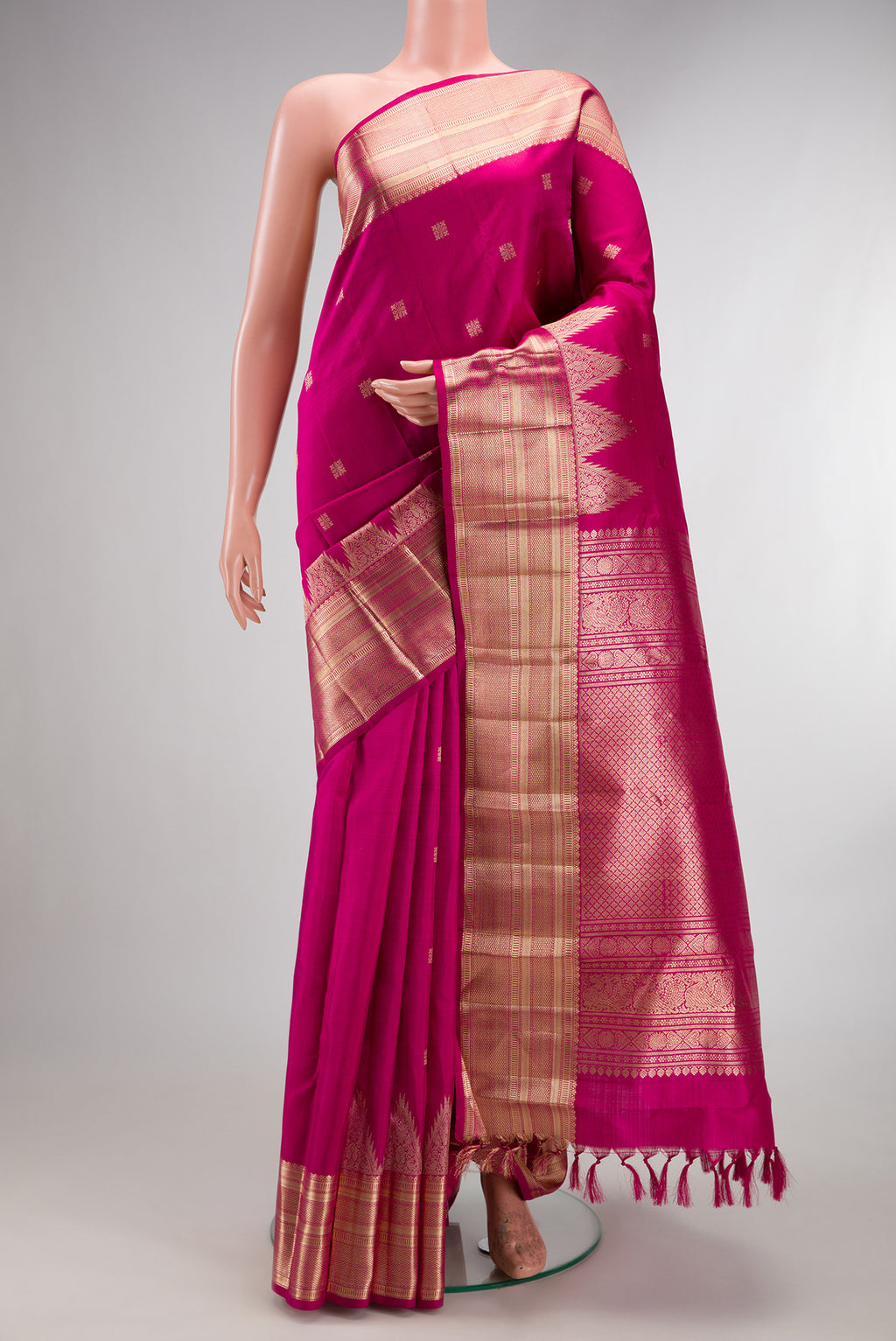 Pure Silk Rani Pink Kanjivaram Saree with Zari Butta on the body and Zari Border.  displayed on a mannequin