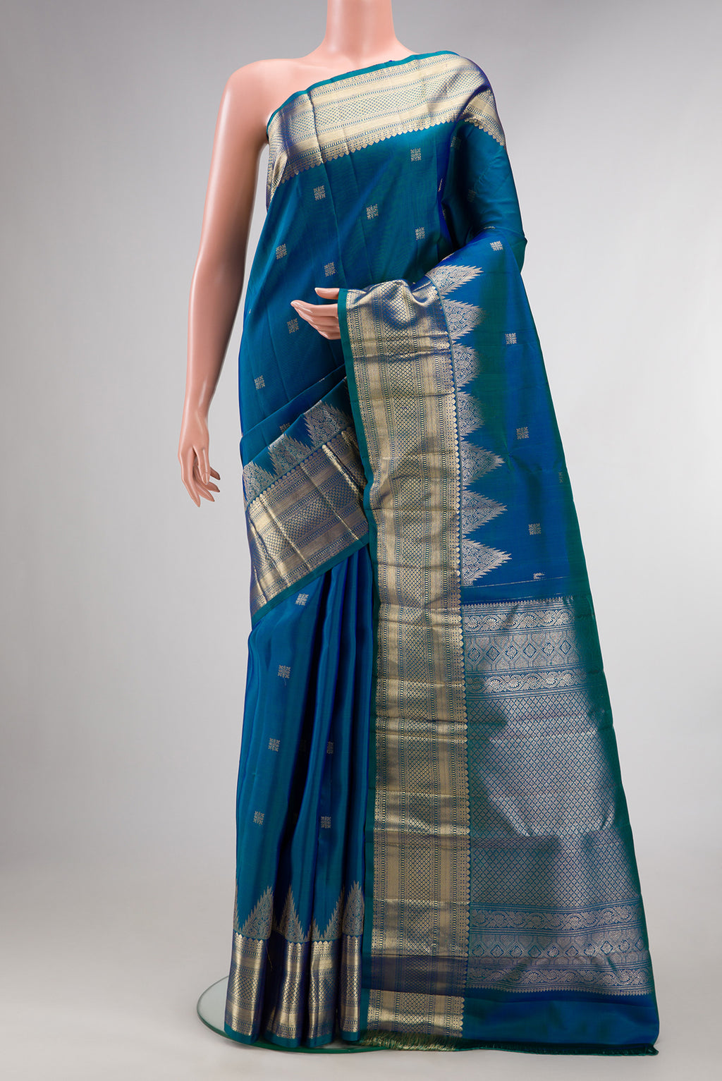 Pure Silk Peacock Blue Dual Tone Kanjivaram Saree with Zari Butta on the body and Fancy Border.  displayed on a mannequin