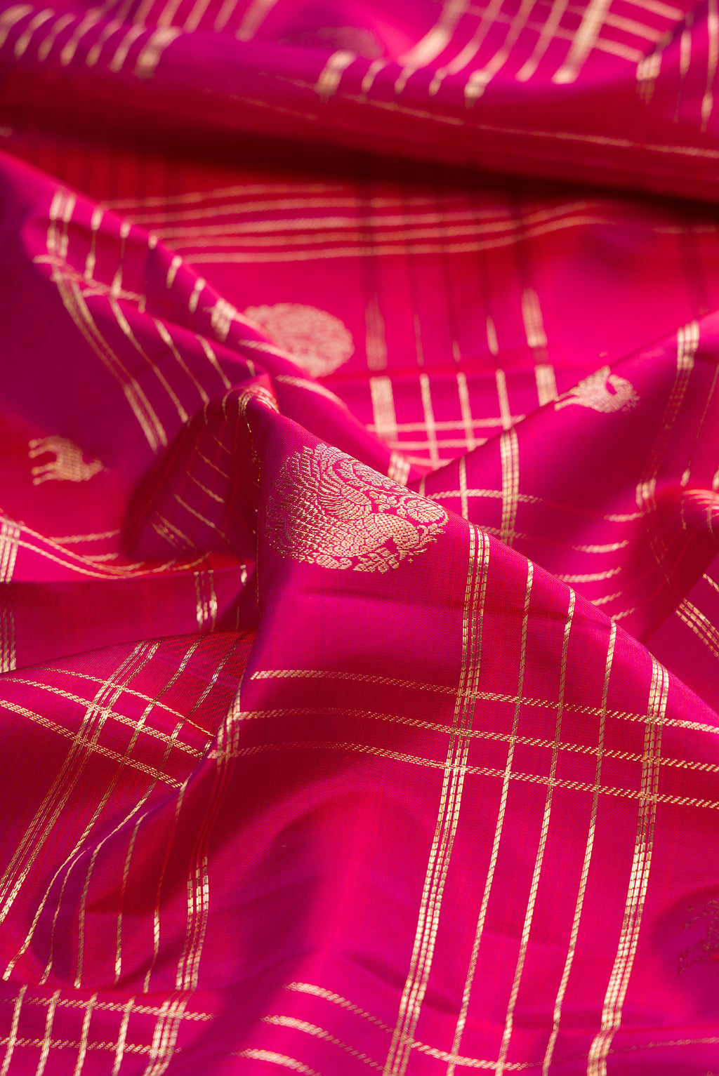 Close up of Pure Silk Dark Pink Dual Tone Kanchipuram Saree with Checked design on the body and Zari Border.  displaying folds