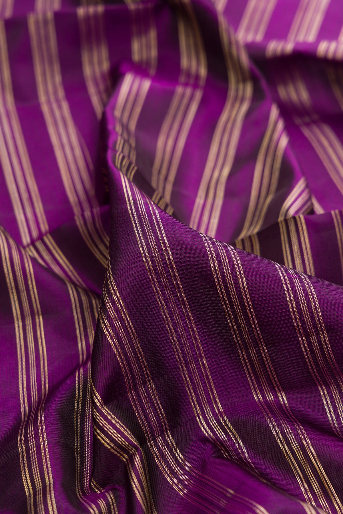 Close up of Pure Silk Purple Kanchipuram Saree with Stripes on the body and Zari Border.  displaying folds