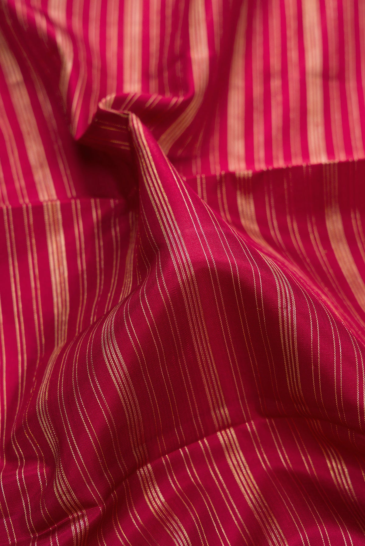 Close up of Pure Silk Red Kanchipuram Saree with Stripes on the body and Temple Border.  displaying folds