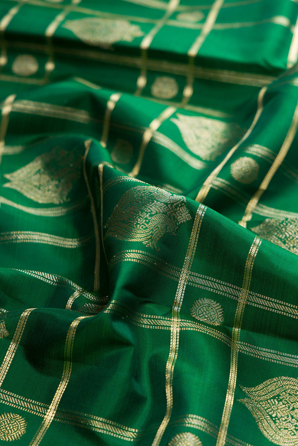 Close up of Pure Silk Green Kanchipuram Saree with Checked design on the body and Zari Border.  displaying folds