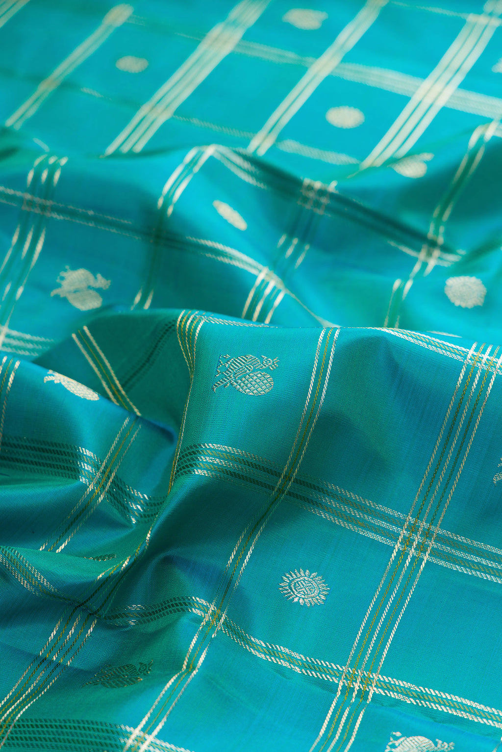 Close up of Pure Silk Turquoise Kanchipuram Saree with Checked design on the body and Zari Border.  displaying folds