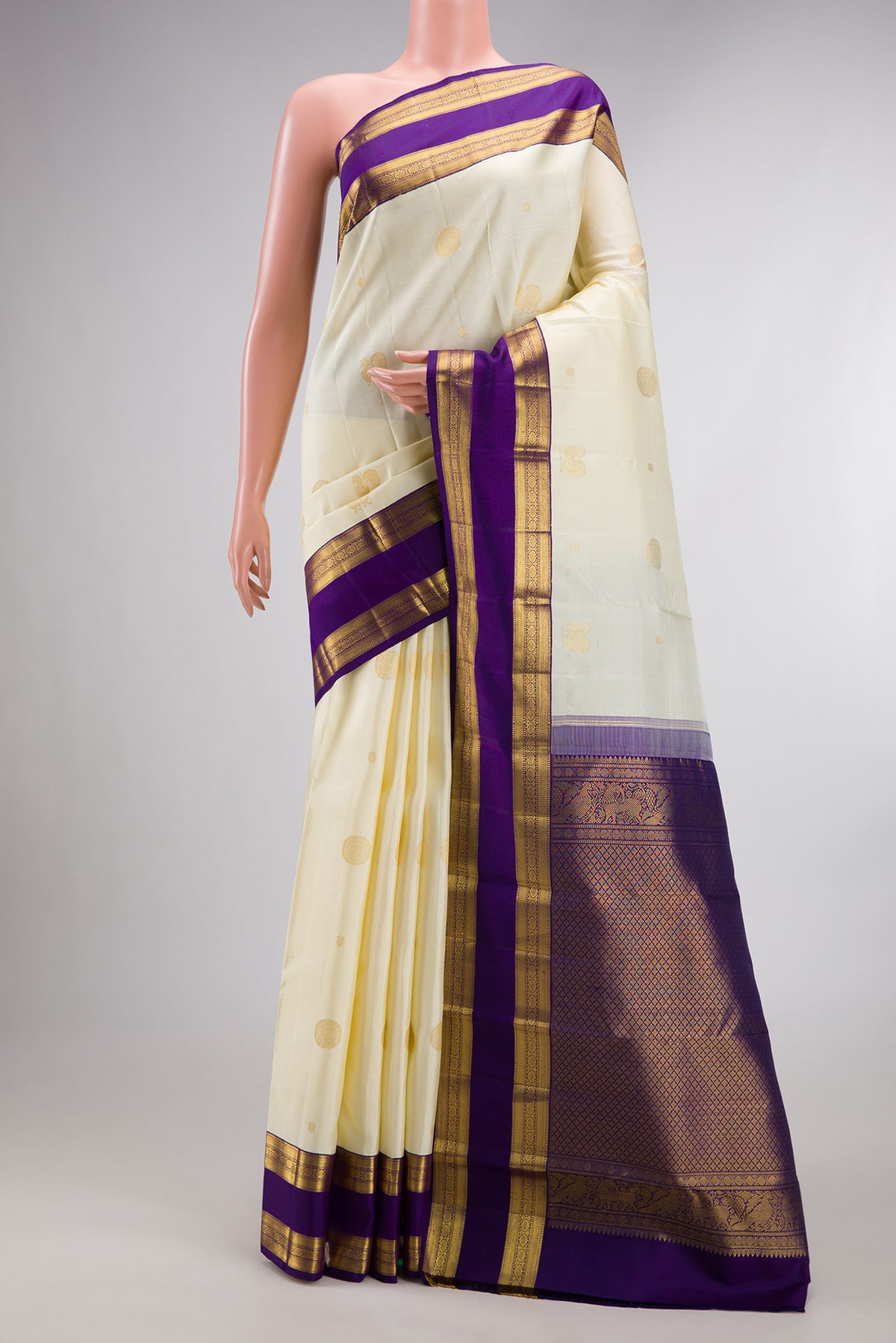 Pure Silk Off White Kanchipuram Saree with Zari Butta on the body and Zari Border.  displayed on a mannequin