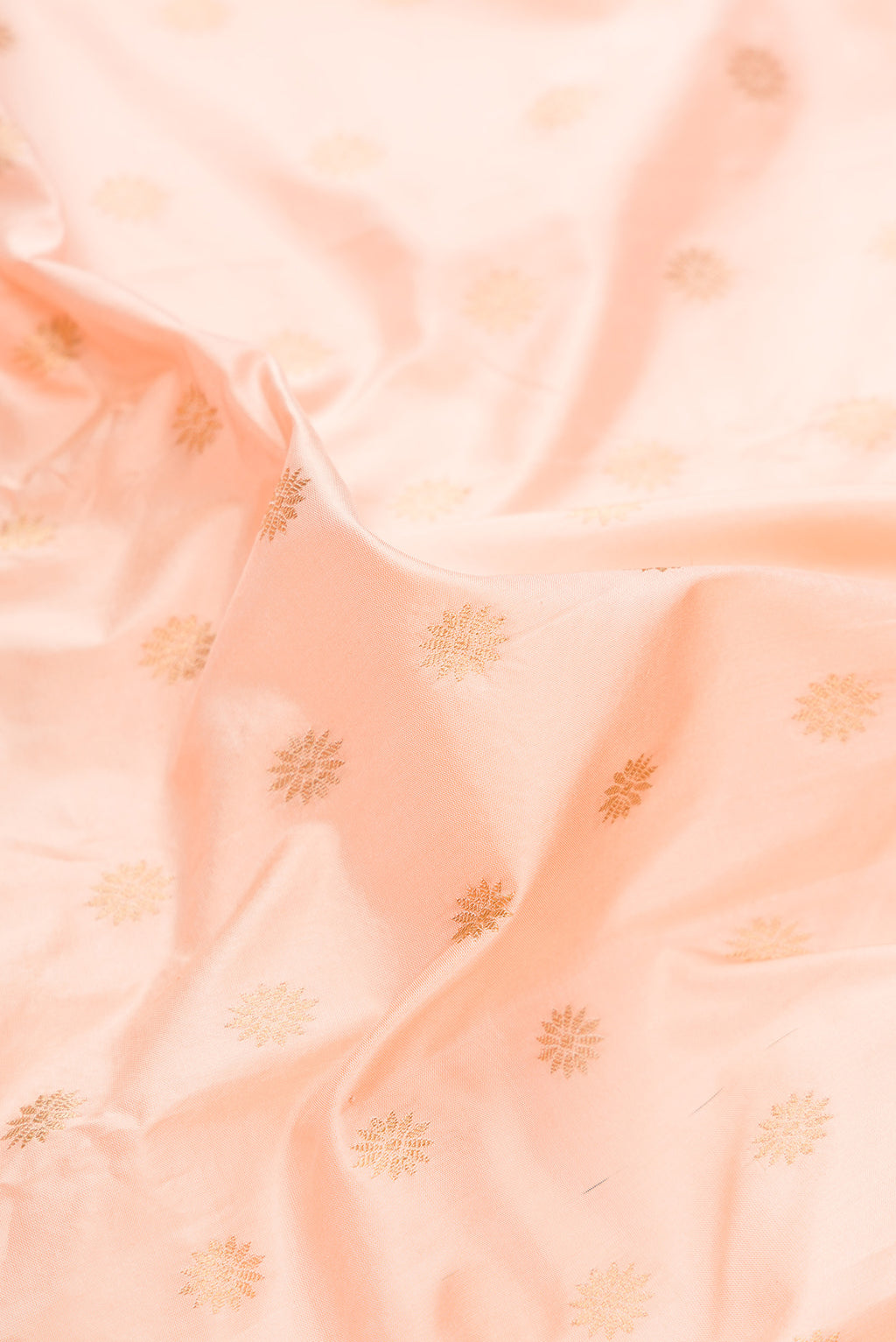 Close up of Pure Silk Peach Paithani Saree with Zari Butta on the body and Zari Border.  displaying folds
