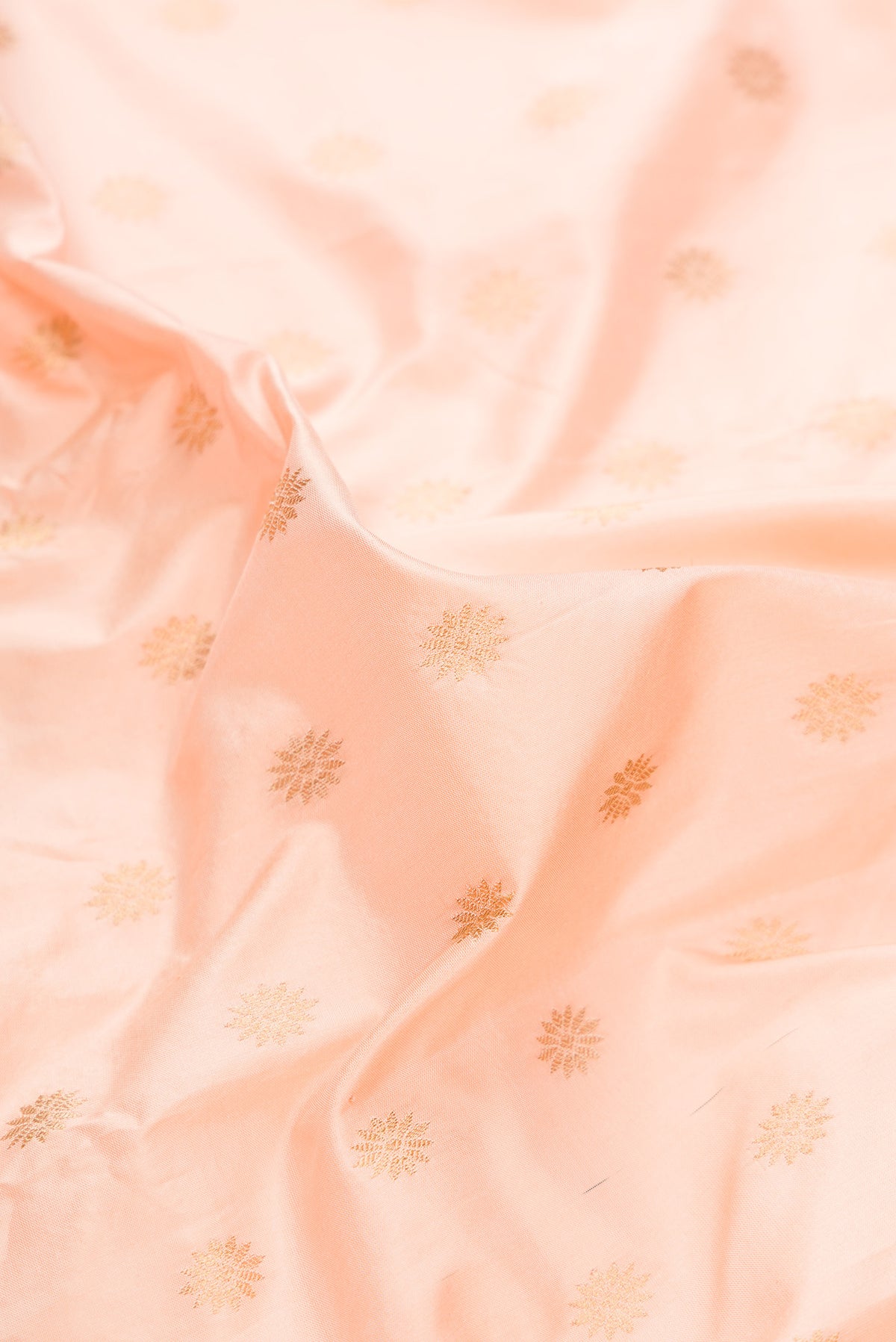 Close up of Pure Silk Peach Paithani Saree with Zari Butta on the body and Zari Border.  displaying folds