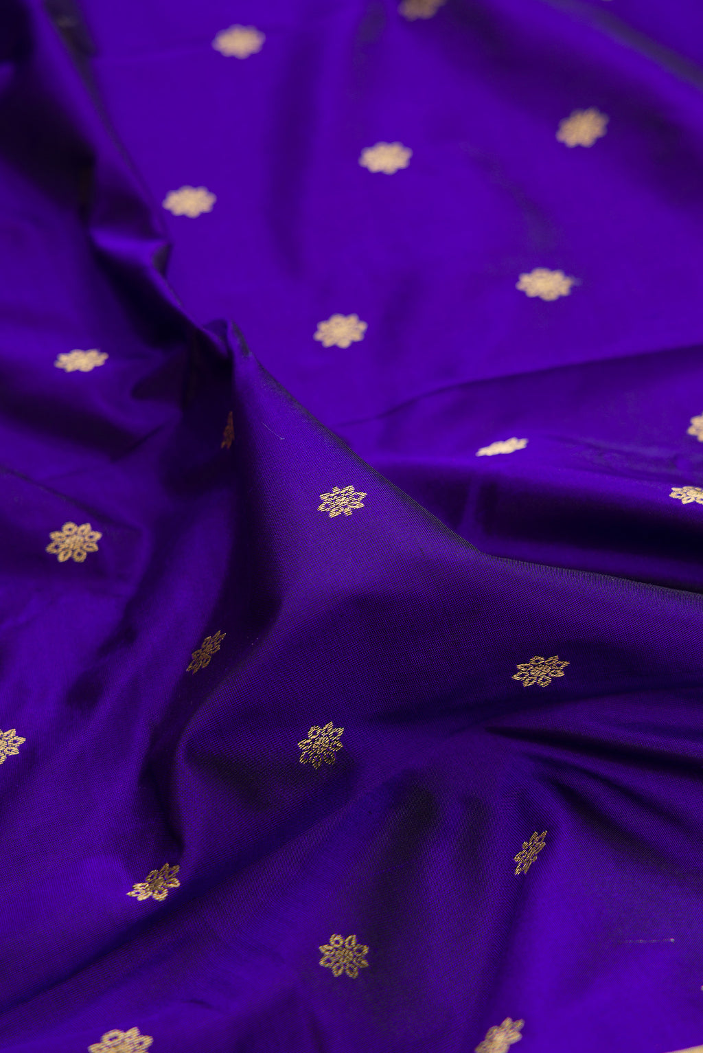 Close up of Pure Silk Royal Blue Paithani Saree with Zari Butta on the body and Zari Border.  displaying folds