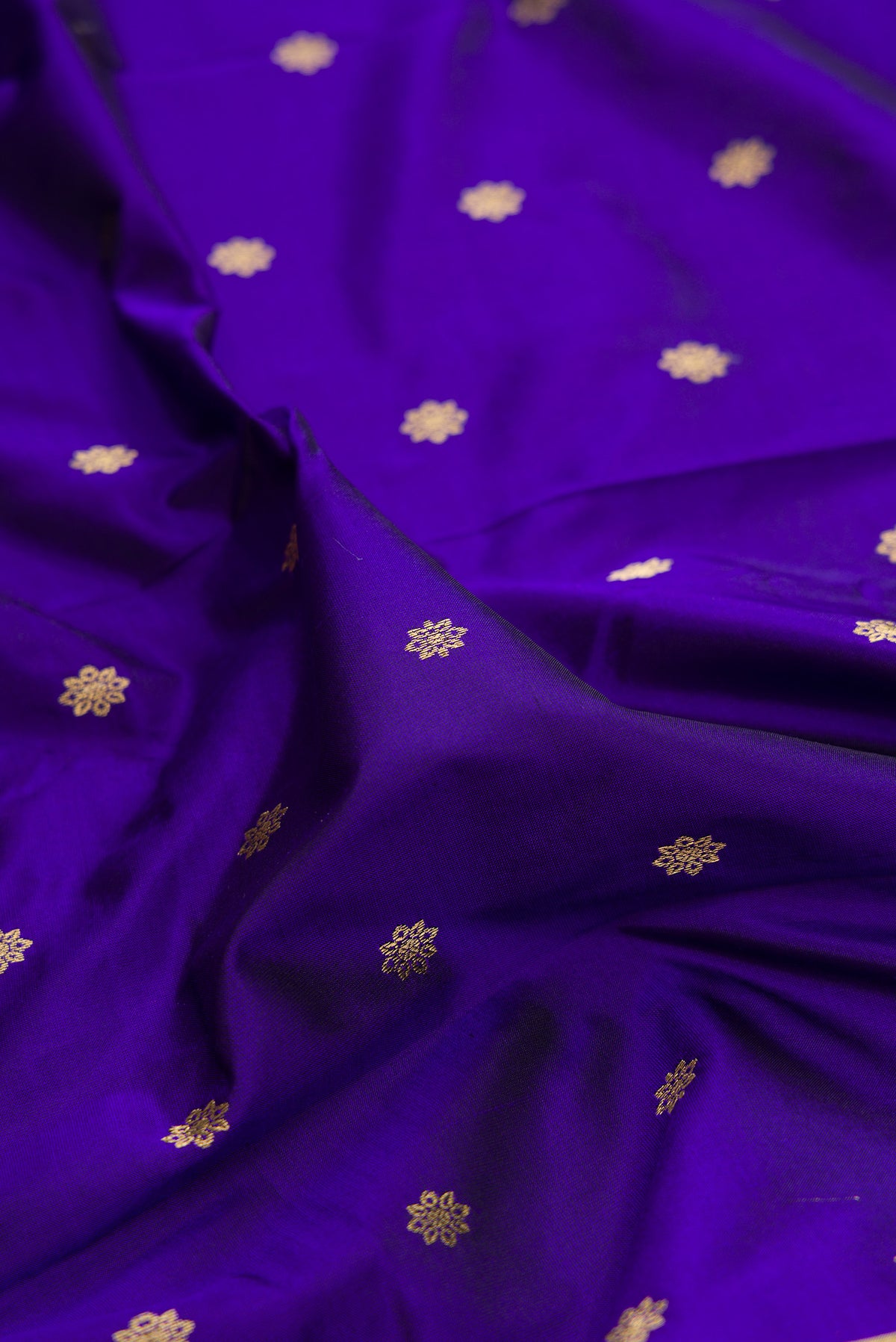 Close up of Pure Silk Royal Blue Paithani Saree with Zari Butta on the body and Zari Border.  displaying folds