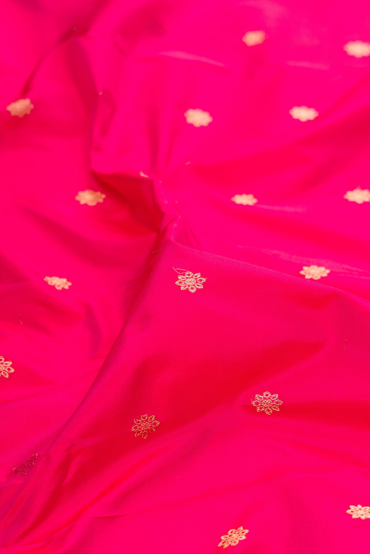 Close up of Pure Silk Dark Pink Paithani Saree with Zari Butta on the body and Zari Border.  displaying folds