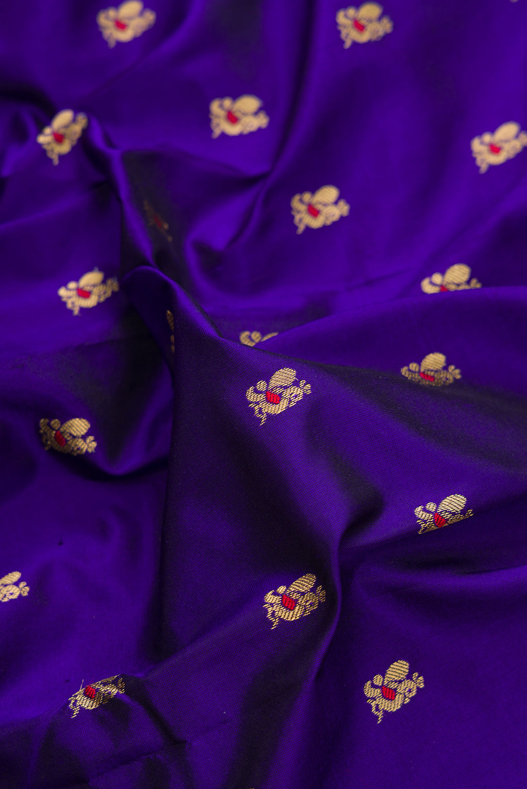 Close up of Pure Silk Royal Blue Paithani Saree with Zari And Thread Butta on the body and Zari Border.  displaying folds
