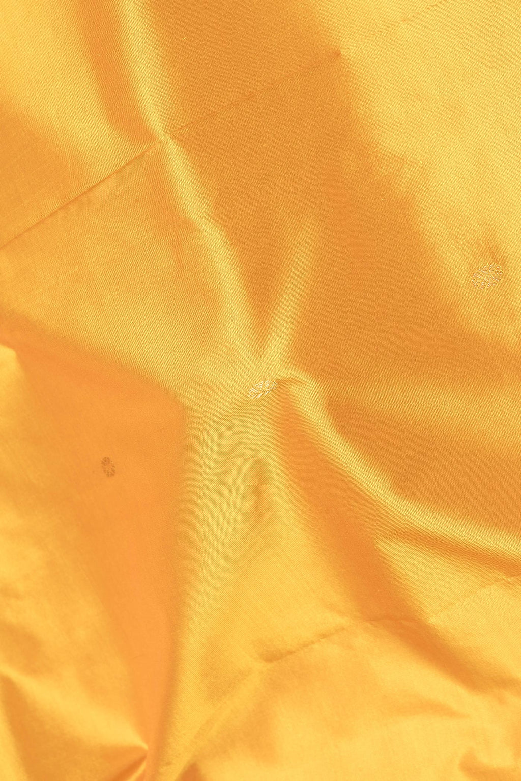 Close up of Pure Silk Yellow Bangalore Saree with Zari Butta on the body and Temple Border.  displaying folds