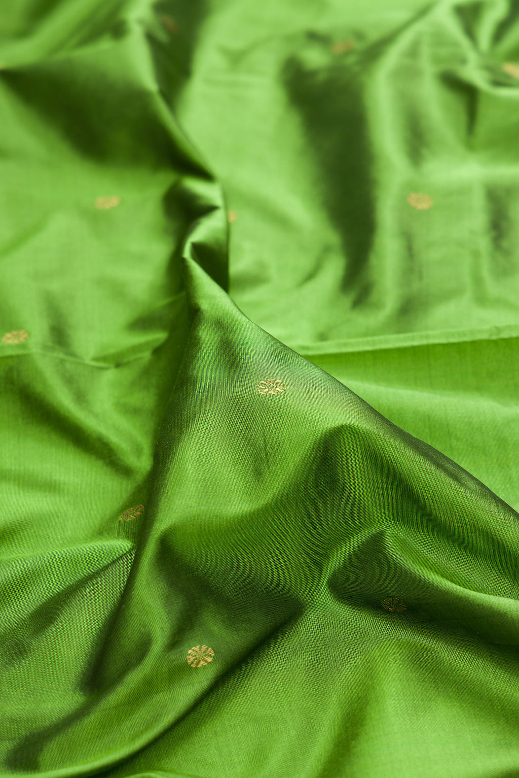 Close up of Pure Silk Green Bangalore Saree with Zari Butta on the body and Temple Border.  displaying folds