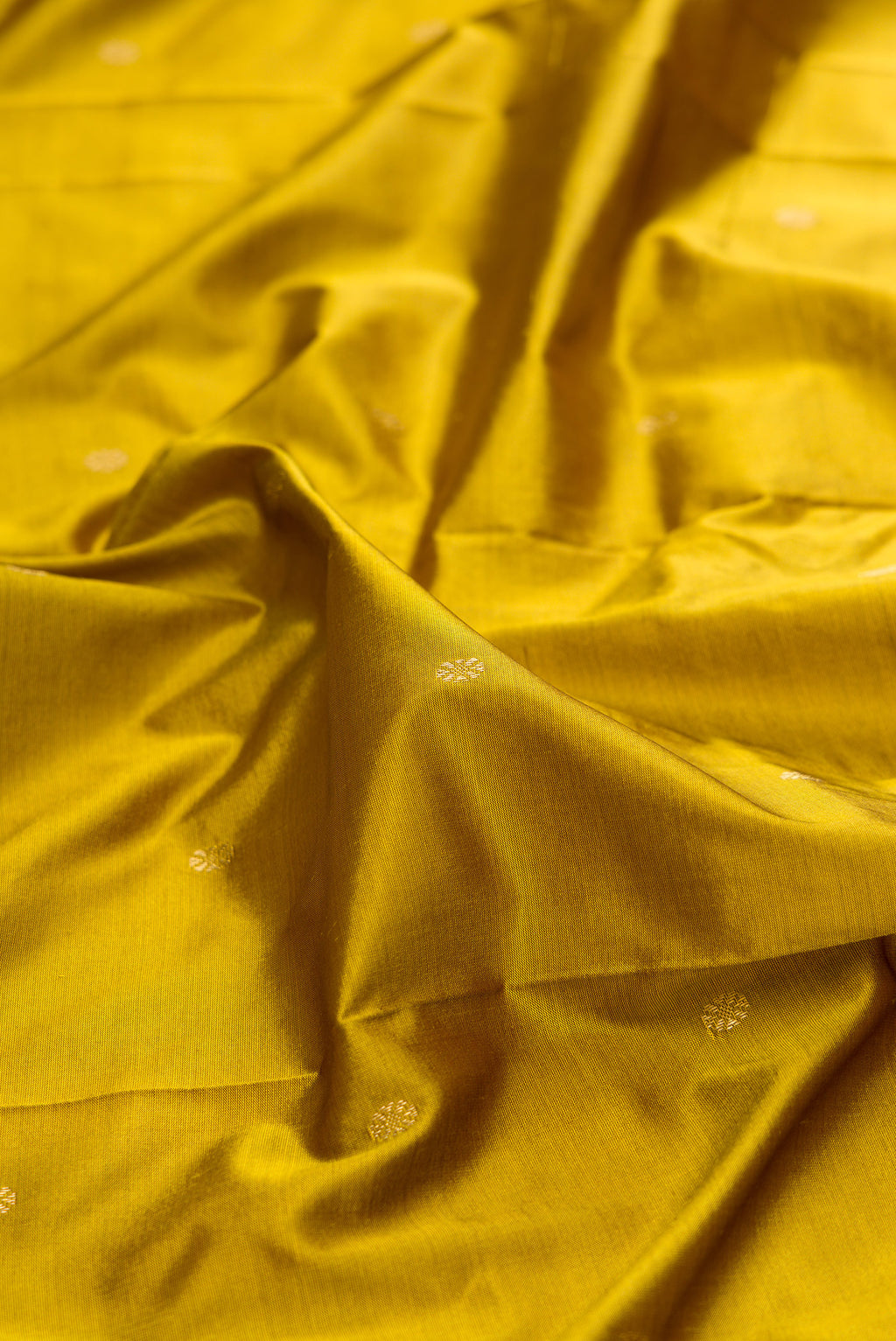 Close up of Pure Silk Mehandi Green Bangalore Saree with Zari Butta on the body and Temple Border.  displaying folds