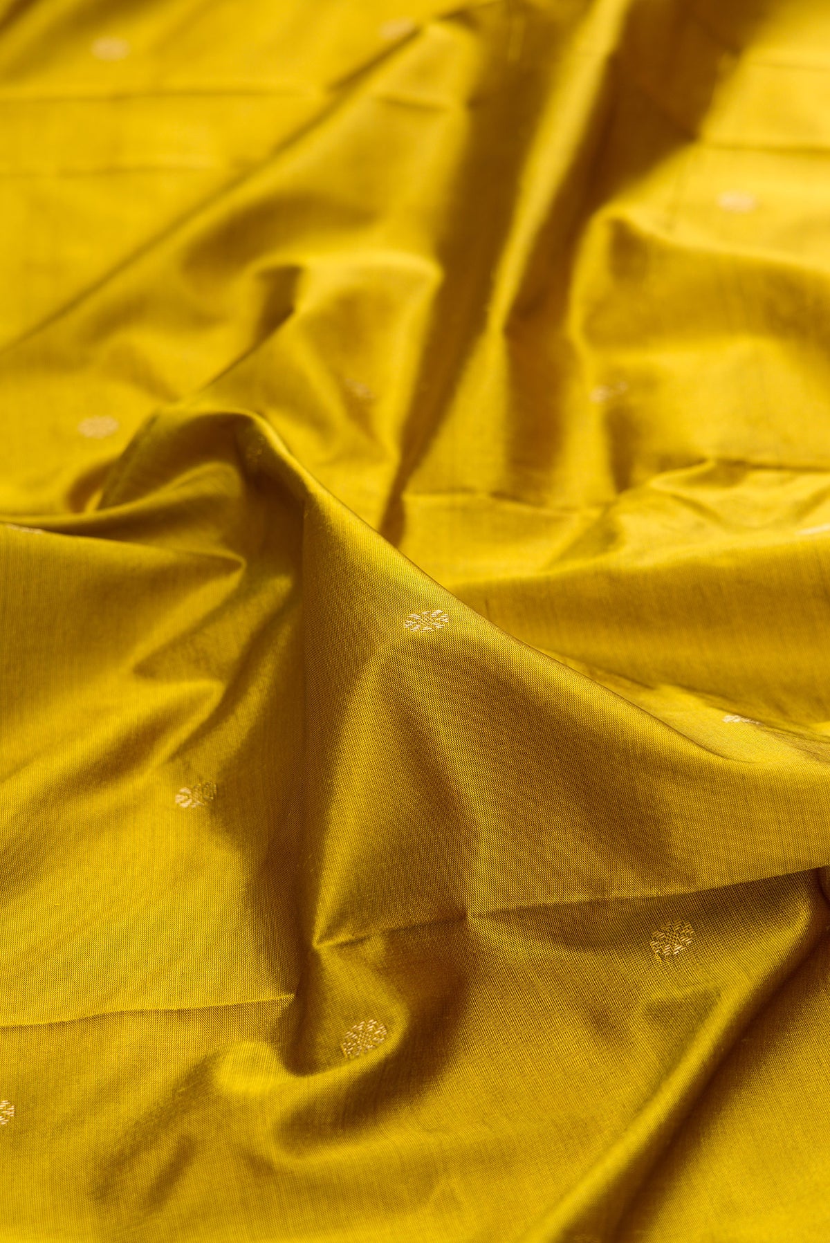 Close up of Pure Silk Mehandi Green Bangalore Saree with Zari Butta on the body and Temple Border.  displaying folds