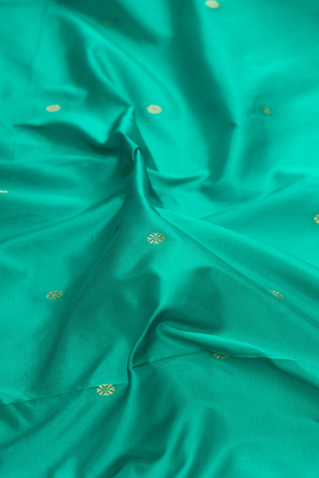 Close up of Pure Silk Green Bangalore Saree with Zari Butta on the body and Temple Border.  displaying folds