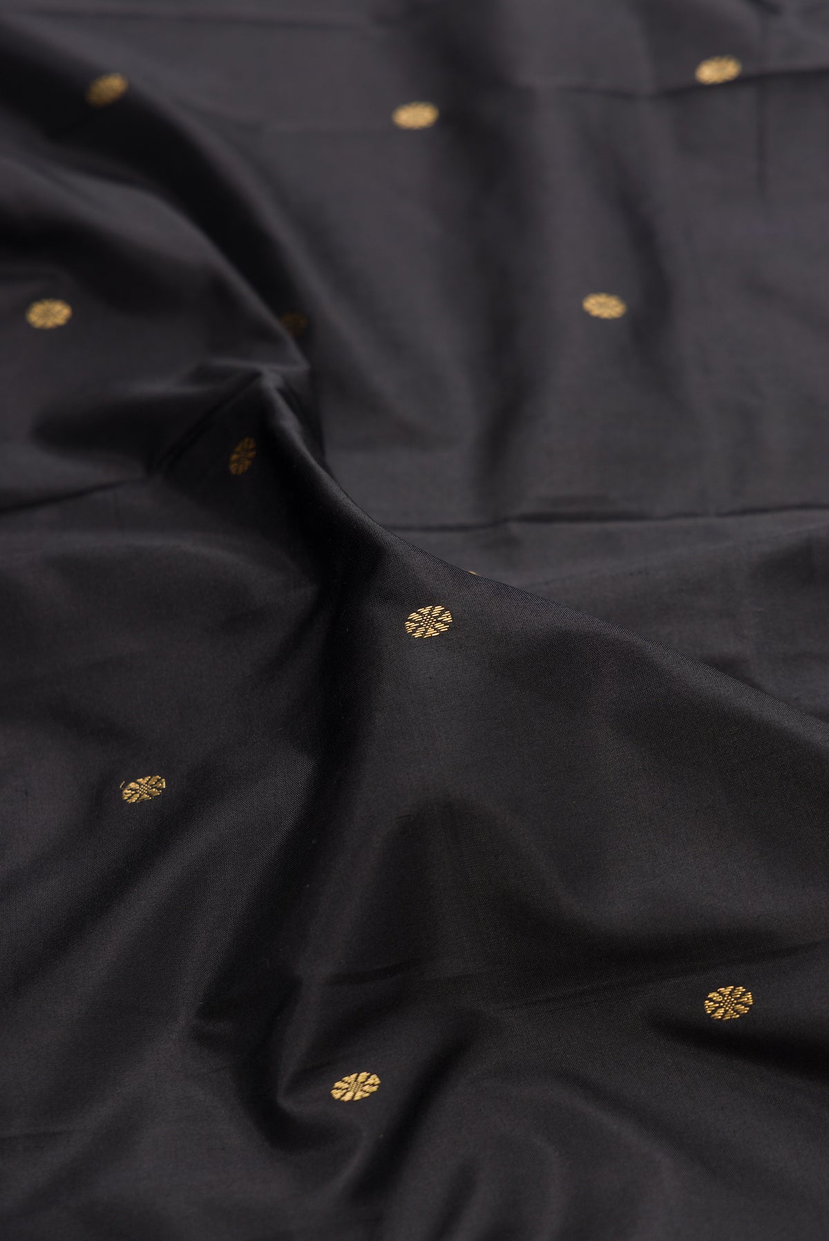 Close up of Pure Silk Black Bangalore Saree with Zari Butta on the body and Temple Border.  displaying folds