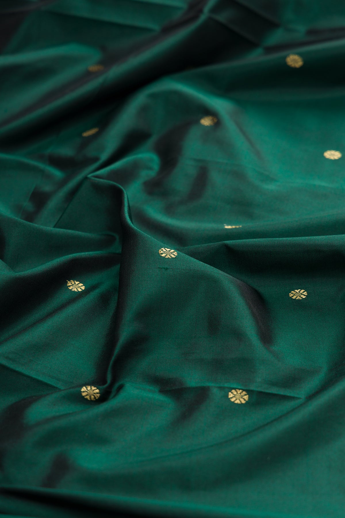 Close up of Pure Silk Bottle Green Bangalore Saree with Zari Butta on the body and Temple Border.  displaying folds