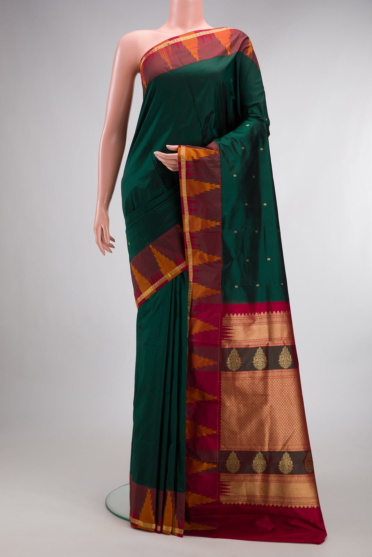 Pure Silk Bottle Green Bangalore Saree with Zari Butta on the body and Temple Border.  displayed on a mannequin