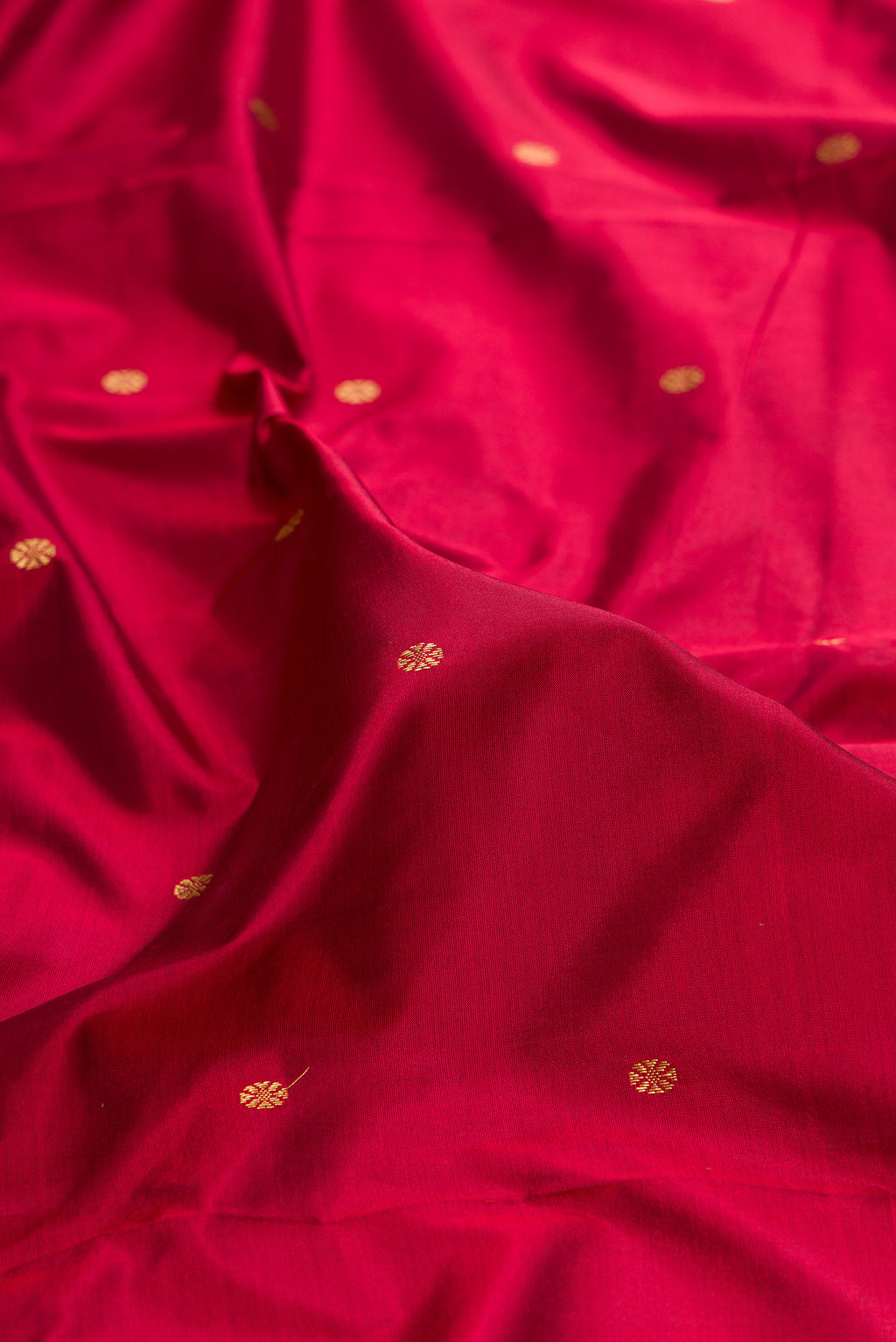 Close up of Pure Silk Maroon Bangalore Saree with Zari Butta on the body and Temple Border.  displaying folds
