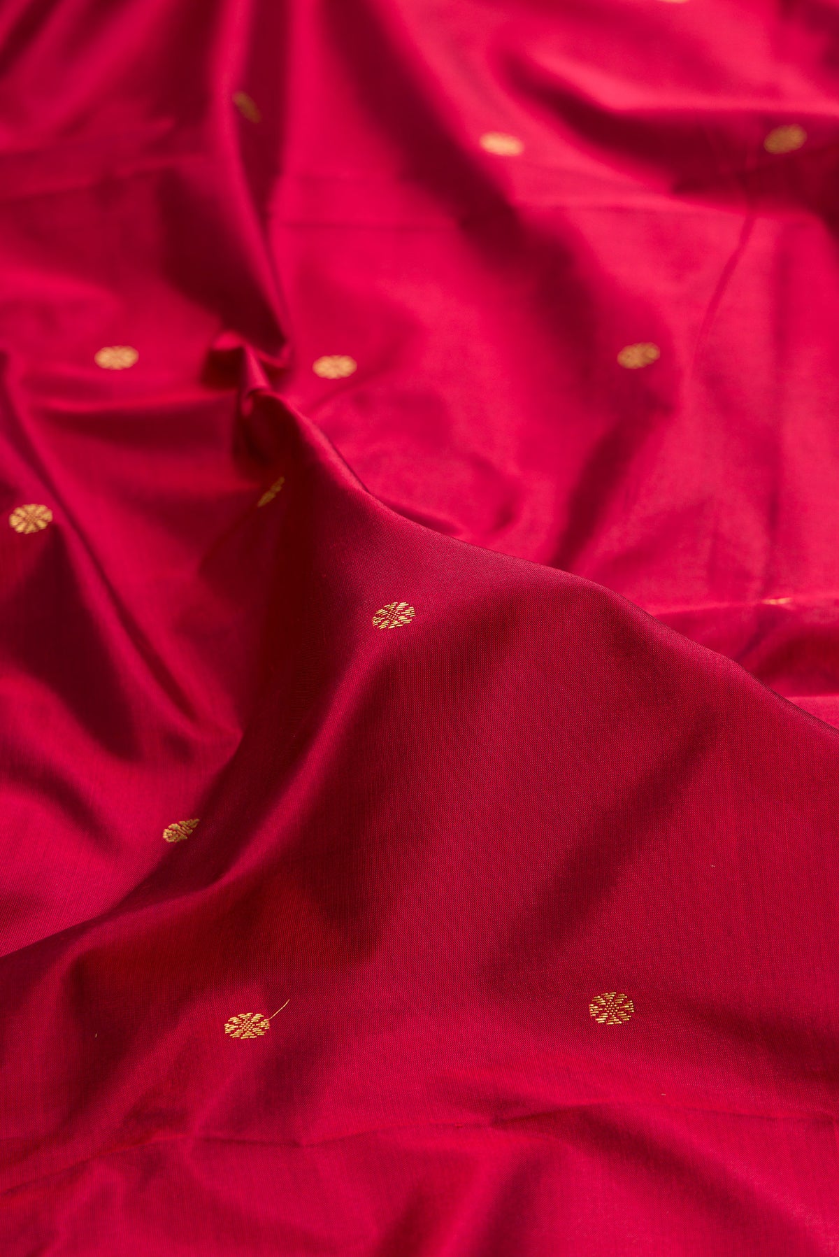 Close up of Pure Silk Maroon Bangalore Saree with Zari Butta on the body and Temple Border.  displaying folds