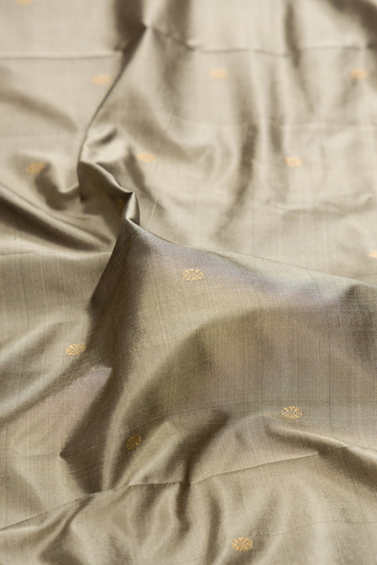 Close up of Pure Silk Grey Bangalore Saree with Zari Butta on the body and Temple Border.  displaying folds