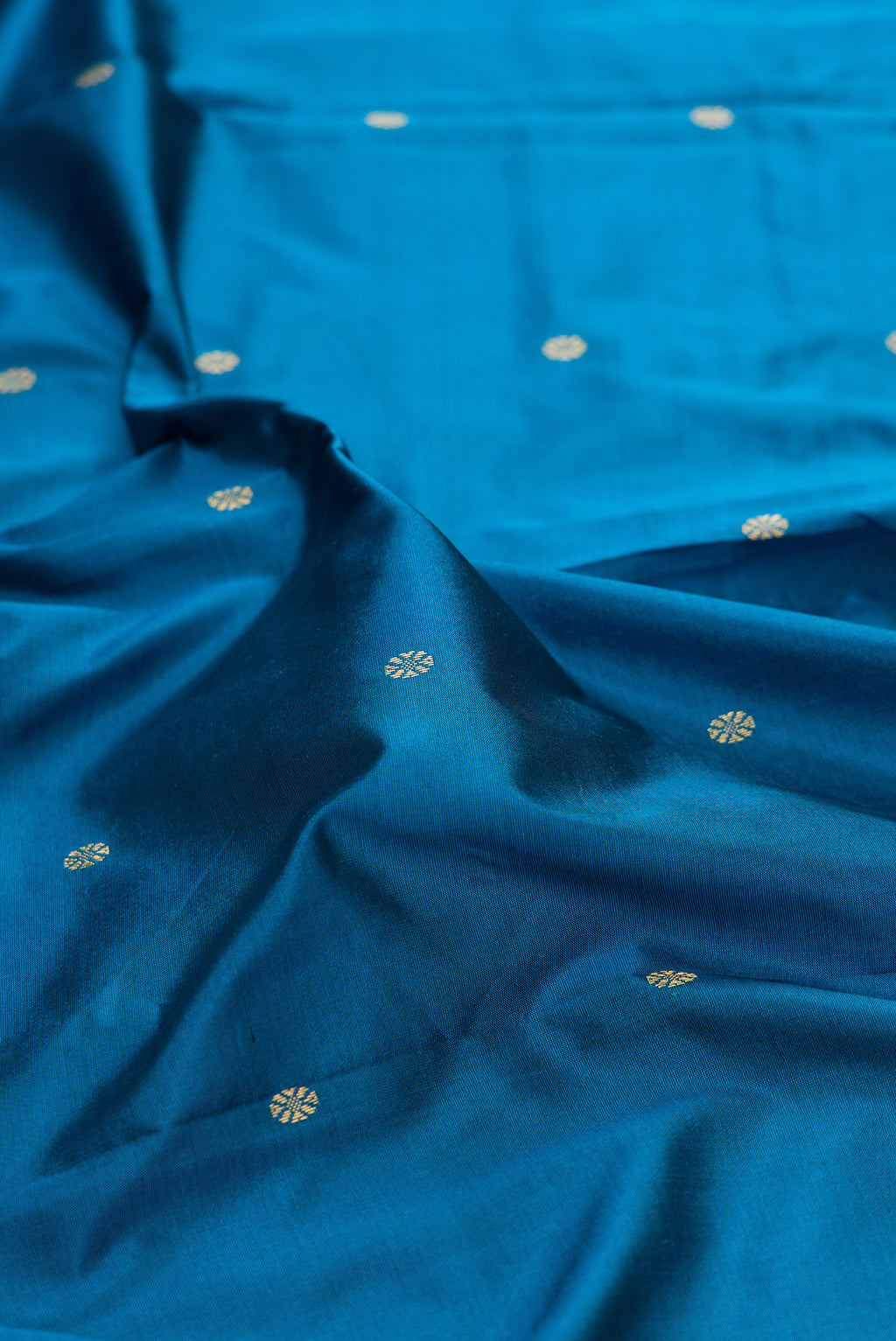 Close up of Pure Silk Peacock Blue Bangalore Saree with Zari Butta on the body and Temple Border.  displaying folds
