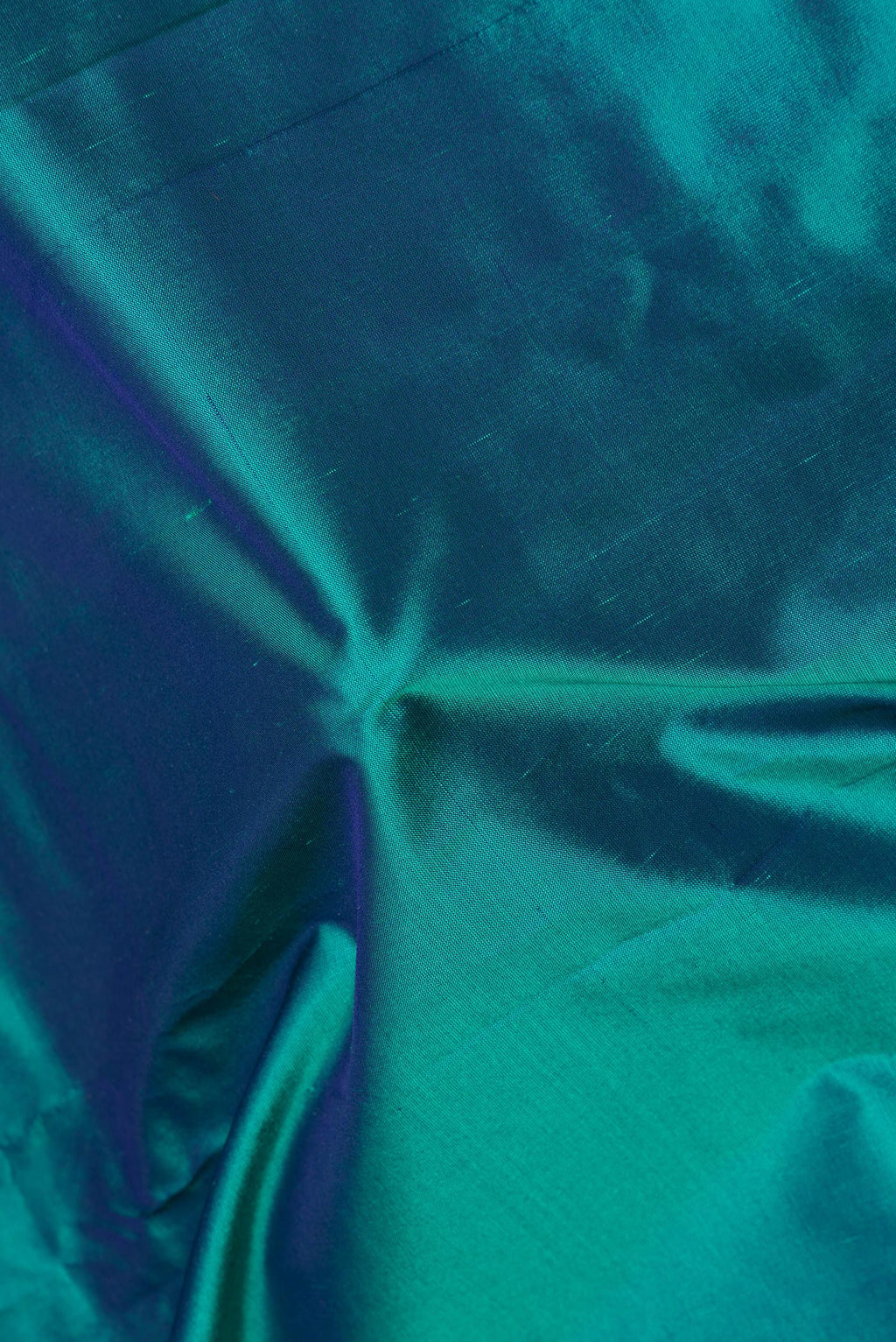 Close up of Pure Silk Peacock Blue Dual Tone Bangalore Saree with Plain Body and Fancy Border.  displaying folds