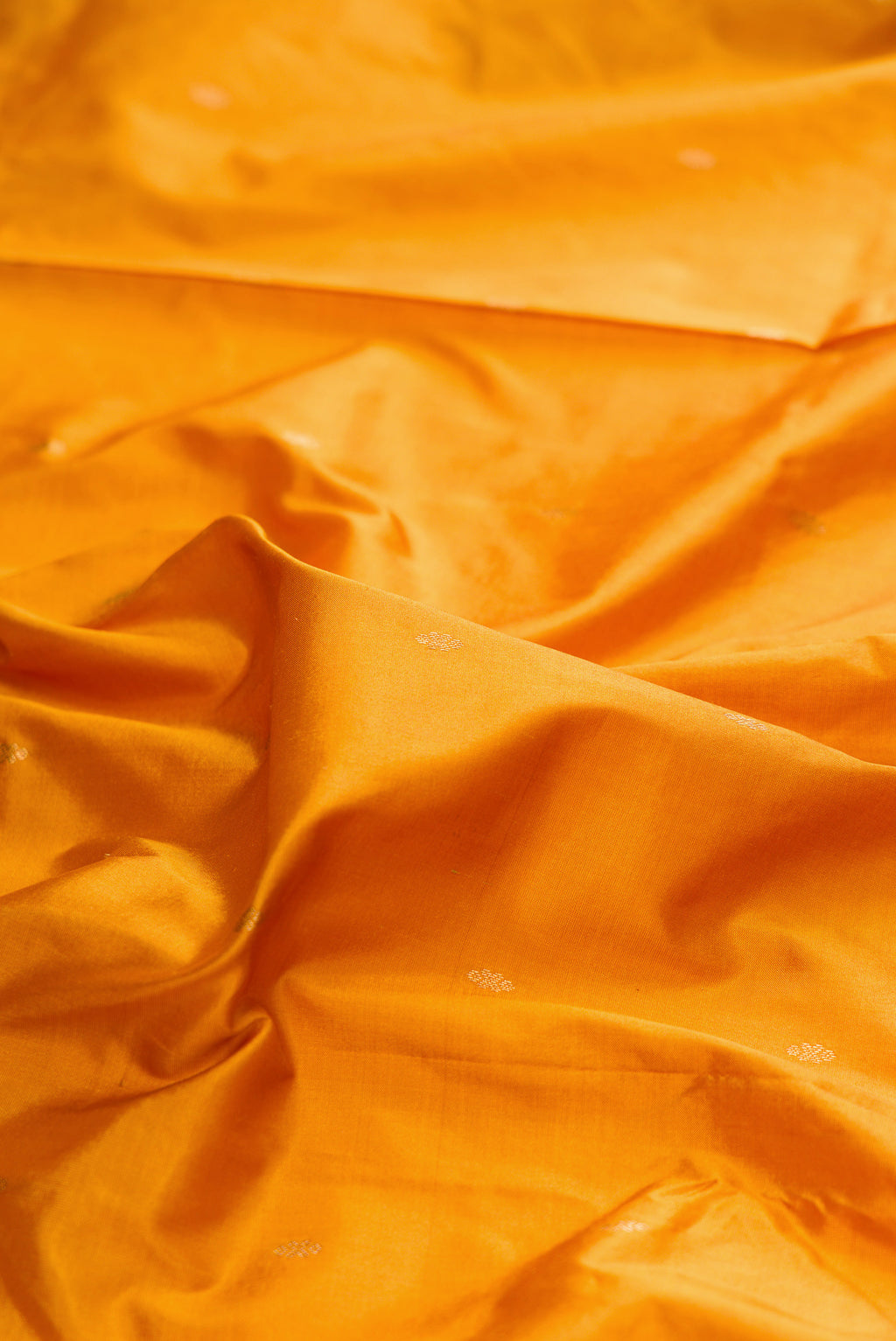 Close up of Pure Silk Mustard Bangalore Saree with Zari Butta on the body and Temple Border.  displaying folds