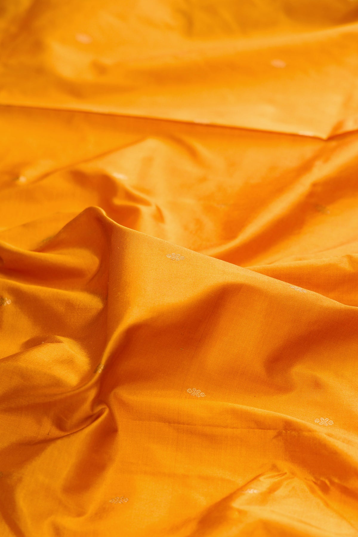 Close up of Pure Silk Mustard Bangalore Saree with Zari Butta on the body and Temple Border.  displaying folds